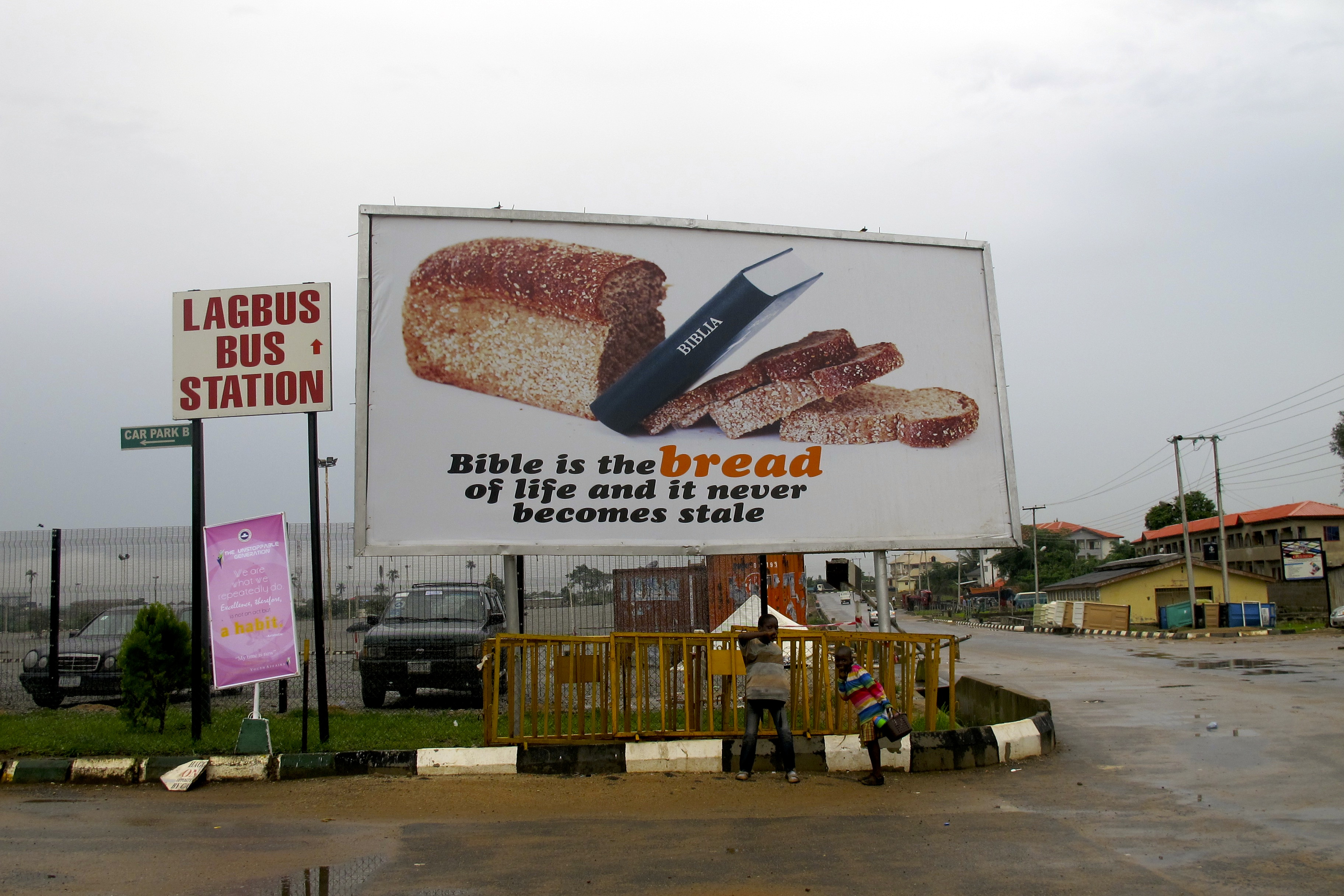 "Bible is the bread of life and it never becomes stale," notes the sign placed alongside a much smaller notice for Nigeria's Lagbus bus service. Image by Richard Vijgen. Nigeria, 2013.