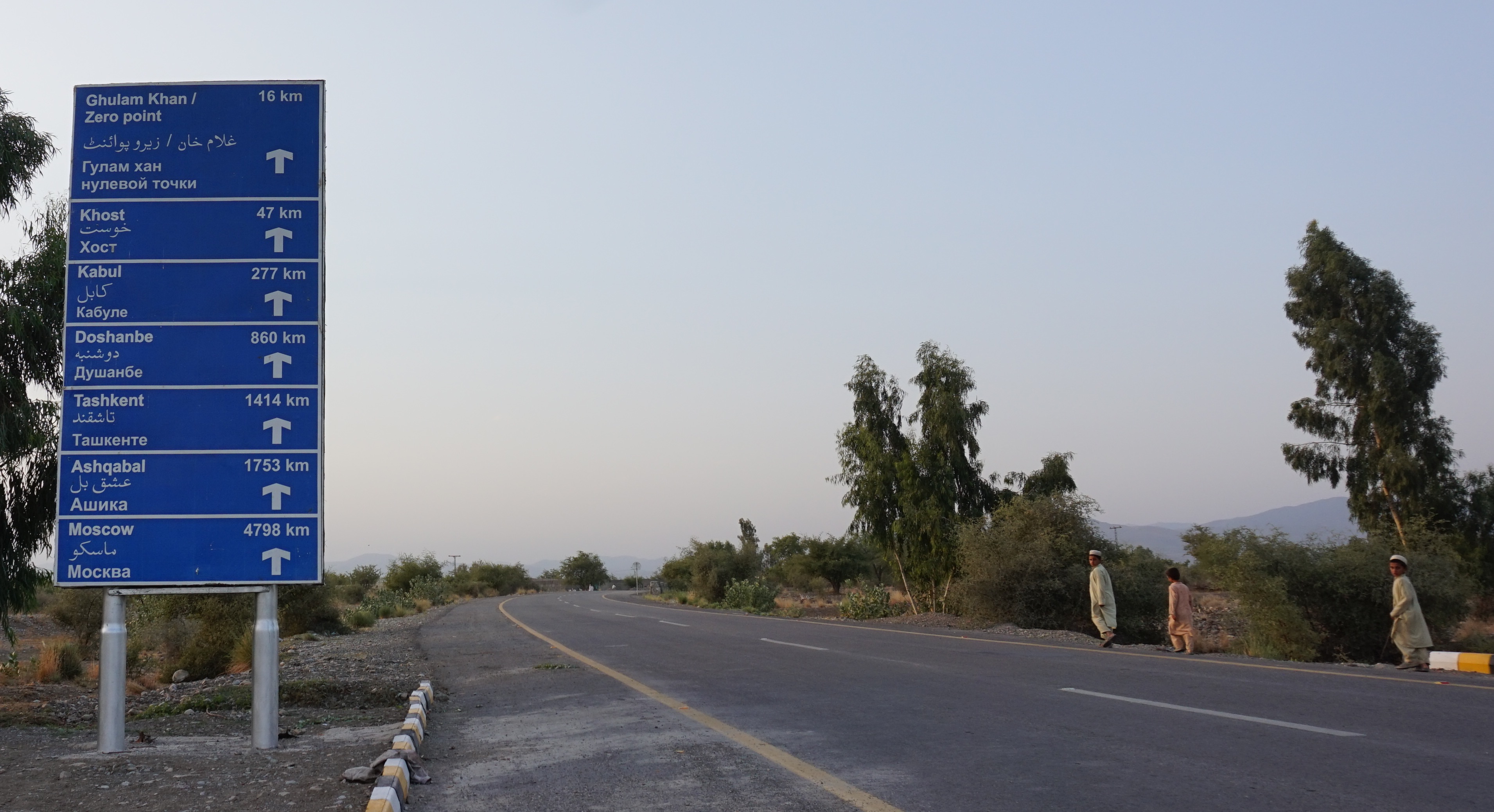 A sign indicating distances in Miran Shah, on the road leading to Afghanistan. Image by Umar Farooq. Pakistan, 2017. A sign indicating distances in Miran Shah, on the road leading to Afghanistan. Image by Umar Farooq. Pakistan, 2017.