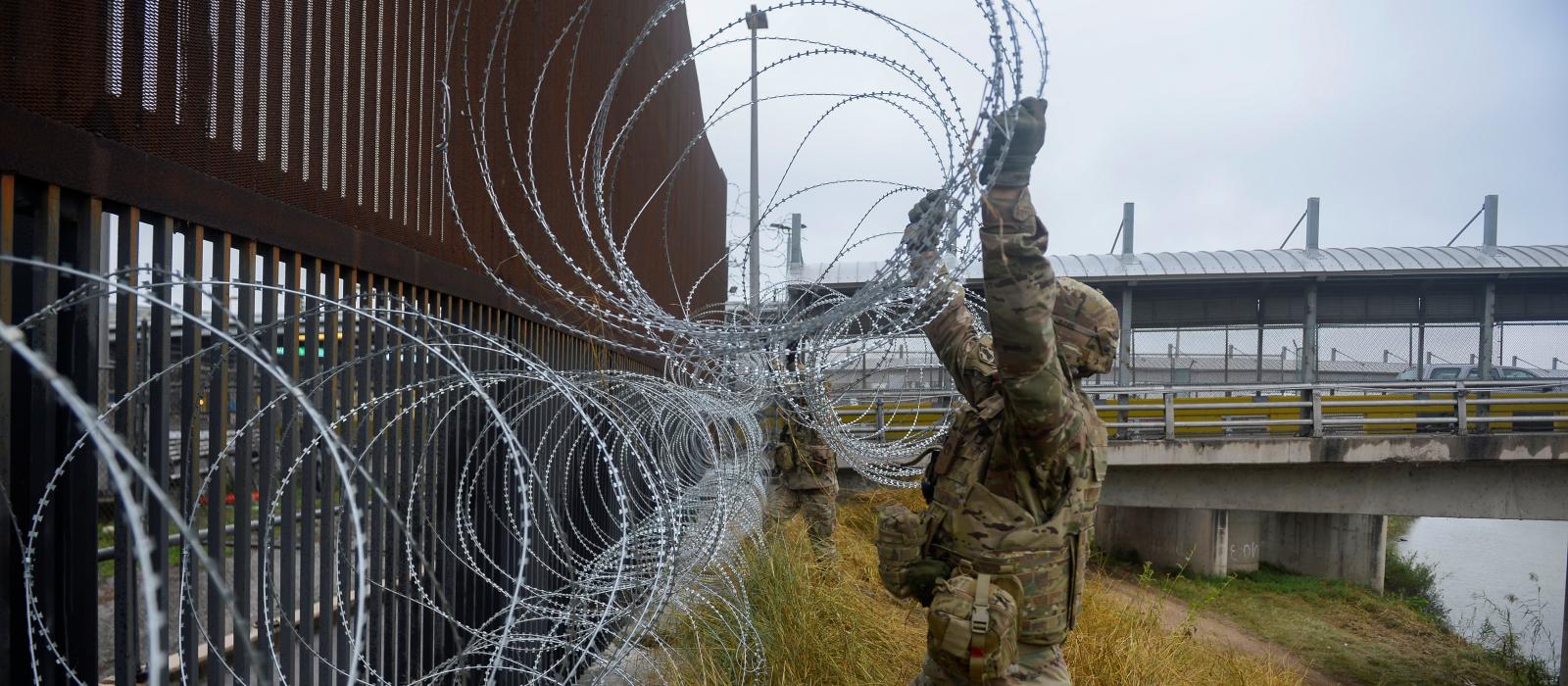 U.S. Army soldiers with the 889th Engineering Support Company, lay concertina wire along the Gateway International Bridge in Brownsville. Image courtesy of U.S. Air Force, via Reuters. United States, 2018. U.S. Army soldiers with the 889th Engineering Support Company, lay concertina wire along the Gateway International Bridge in Brownsville. Image courtesy of U.S. Air Force, via Reuters. United States, 2018.