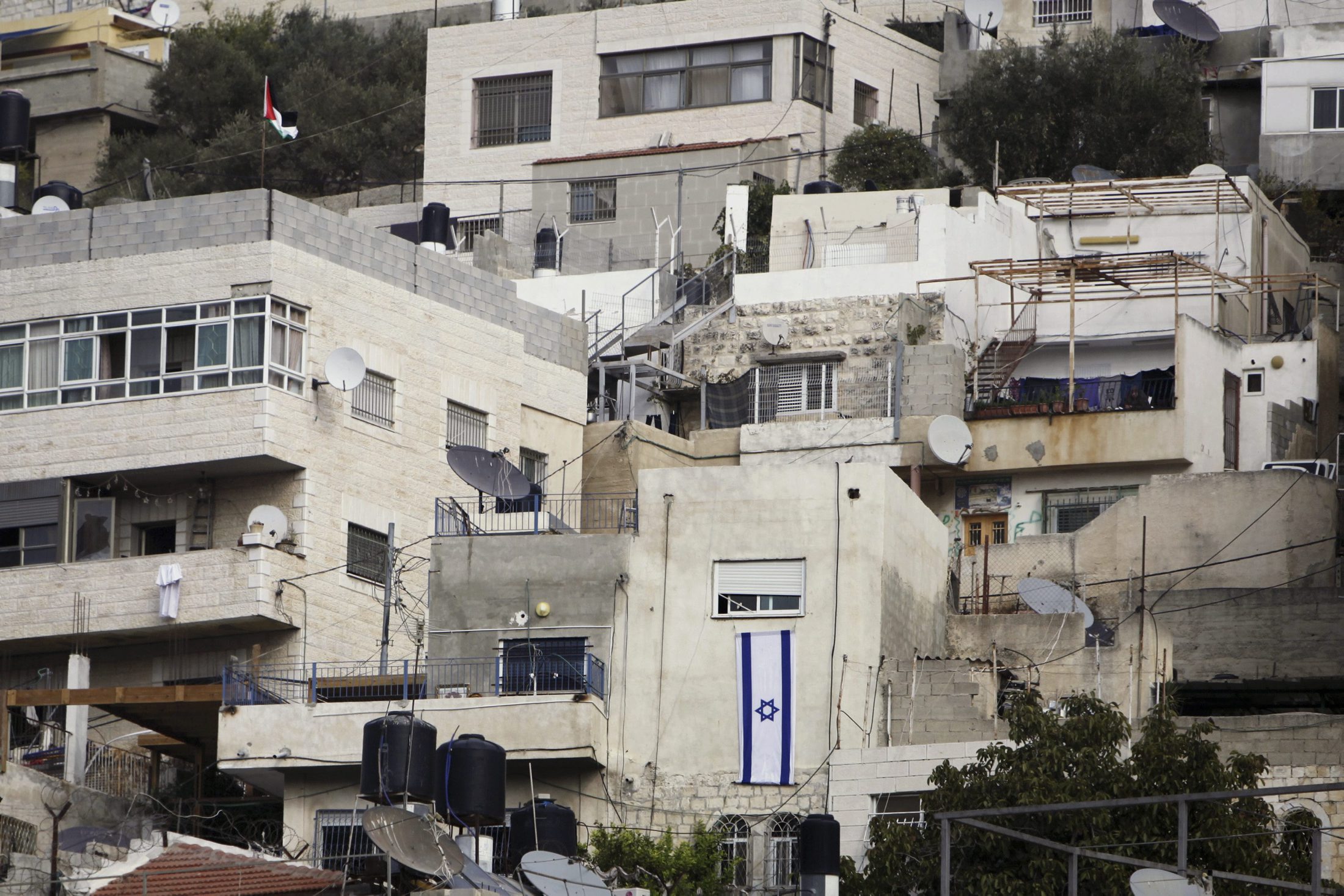 An Israeli flag hangs on the wall of a building that was taken over by Israeli settlers after Palestinian families were evicted in Silwan. Image / AP.