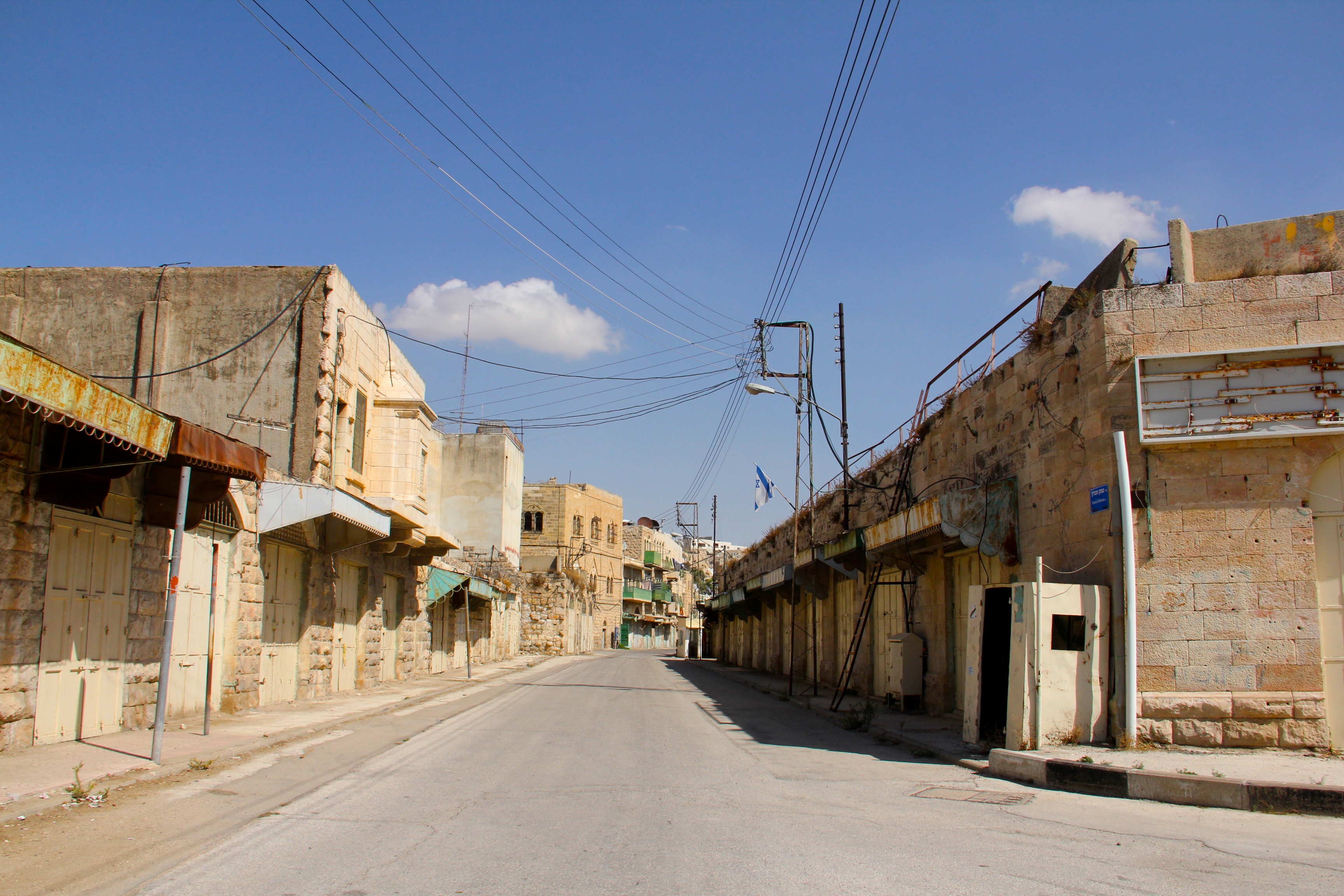 A deserted street with shuttered shops in Hebron. Some areas of the city are off-limits to Palestinians. Image by Uri Blau, West Bank, 2015. Media file: img_9451.jpg