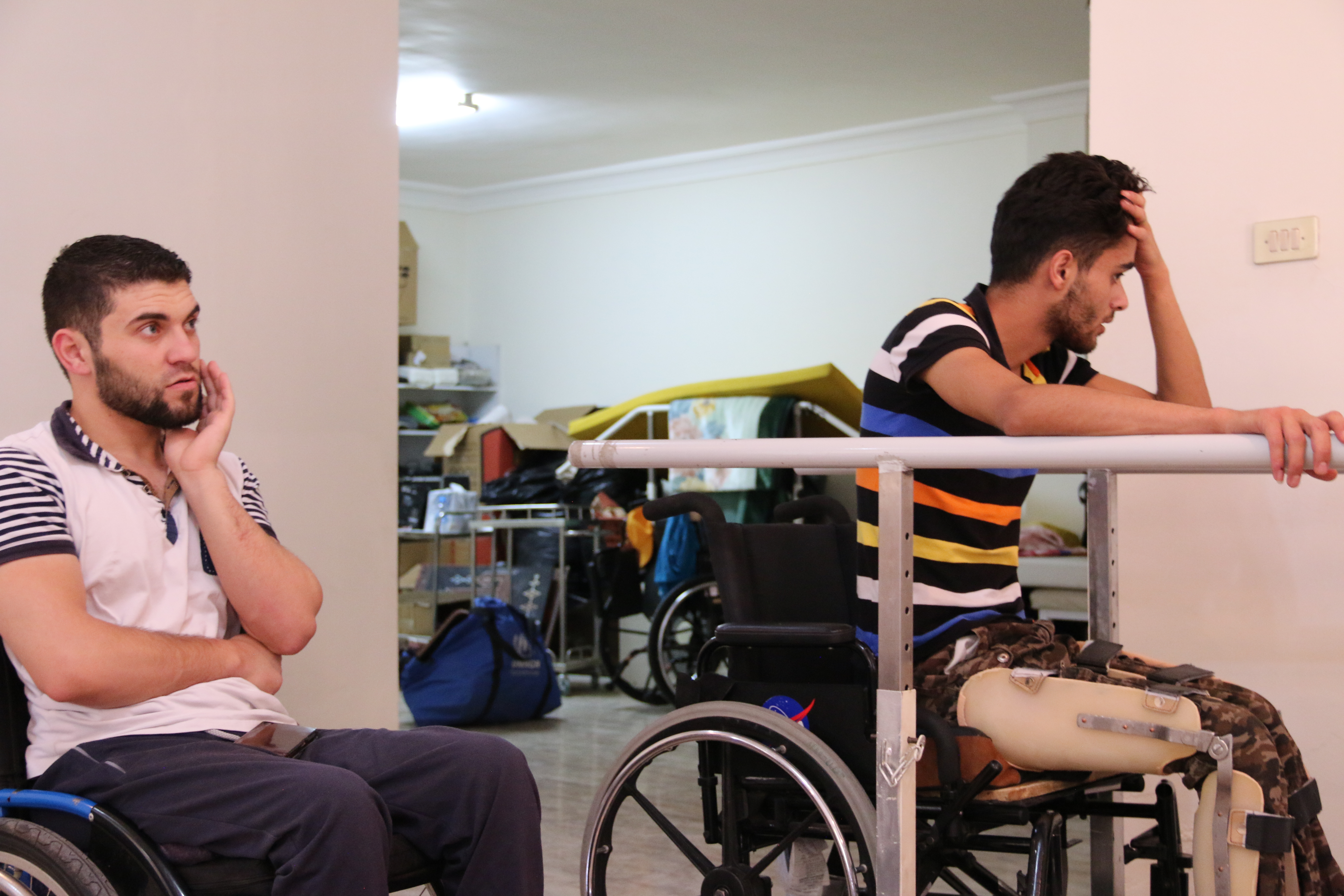 Obada Alasmi sits in on Mohammed Ayyash's training session. Ayyash is confined to a wheelchair,, but they discuss the possibility of using a walker in the near future. Image by Sawsan Morrar. Jordan, 2017. Obada Alasmi sits in on Mohammed Ayyash's training session. Ayyash is confined to a wheelchair,, but they discuss the possibility of using a walker in the near future. Image by Sawsan Morrar. Jordan, 2017.