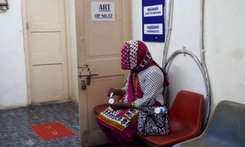 An HIV-positive woman peels the labels off her medication at the government ART center so that her family members will not discover her HIV status. Image by Aditi Kantipuly. India, 2016.