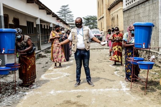 Christian, a Catholic Relief Services staff member, center, instructs aid beneficiaries in Kinshasa, Congo. Image by Justin Makangara/Catholic Relief Services. Democratic Republic of the Congo, undated. Christian, a Catholic Relief Services staff member, center, instructs aid beneficiaries in Kinshasa, Congo. Image by Justin Makangara/Catholic Relief Services. Democratic Republic of the Congo, undated.