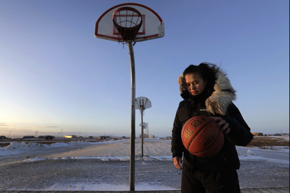 In this Feb. 17, 2019, photo, Deidre Levi carries her basketball as she walks to work in the Native Village of St. Michael, Alaska. Levi says she spoke up about being sexually assaulted because she wanted to be a role model for girls in Alaska. Image by Wong Maye-E/Associated Press. United States, 2019. In this Feb. 17, 2019, photo, Deidre Levi carries her basketball as she walks to work in the Native Village of St. Michael, Alaska. Levi says she spoke up about being sexually assaulted because she wanted to be a role model for girls in Alaska. Image by Wong Maye-E/Associated Press. United States, 2019.