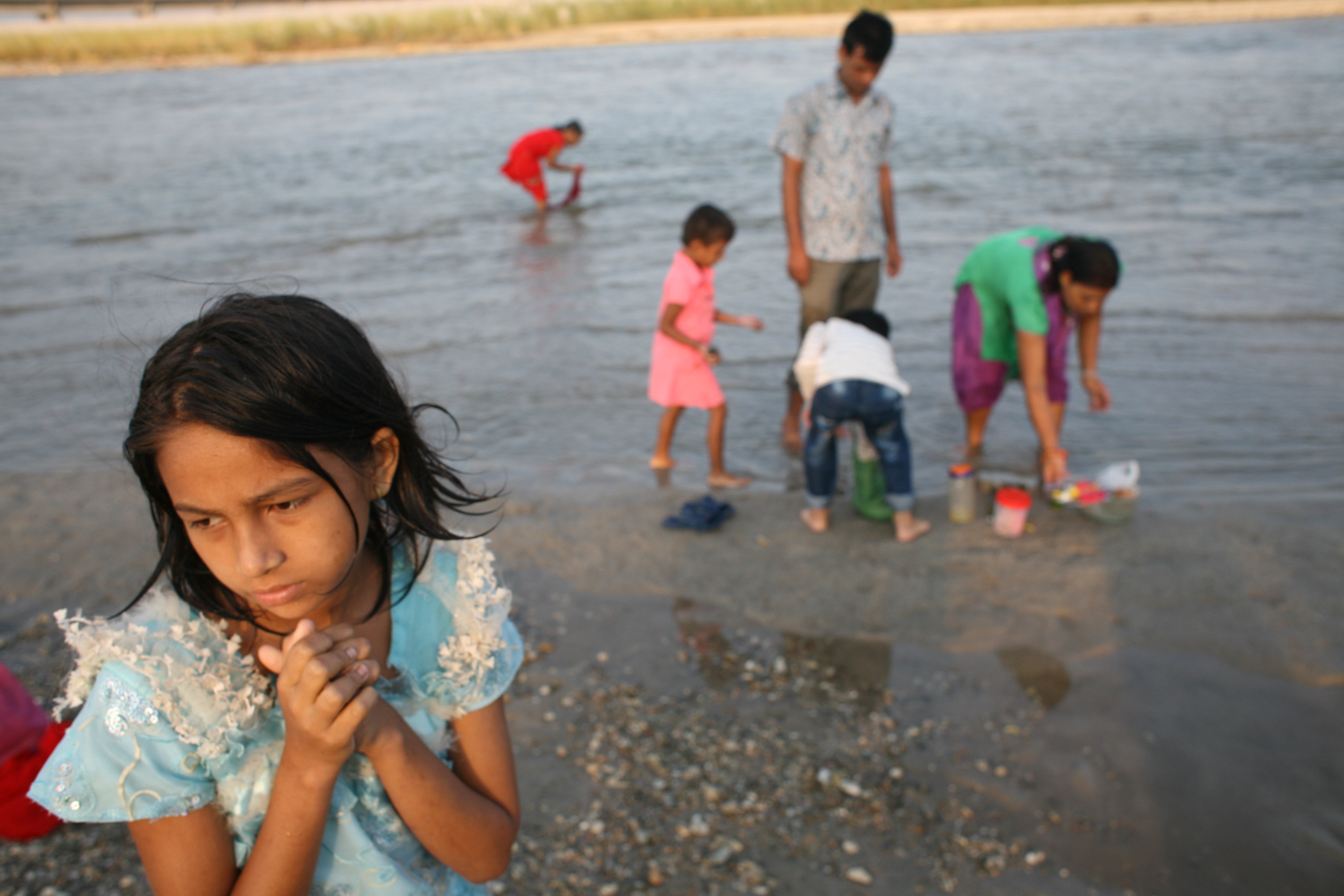 A girl worships with her family on a small river in the town of Jhapa, Nepal. Image by Steve Matzker. Nepal, 2013. Media file: img_3775.jpg
