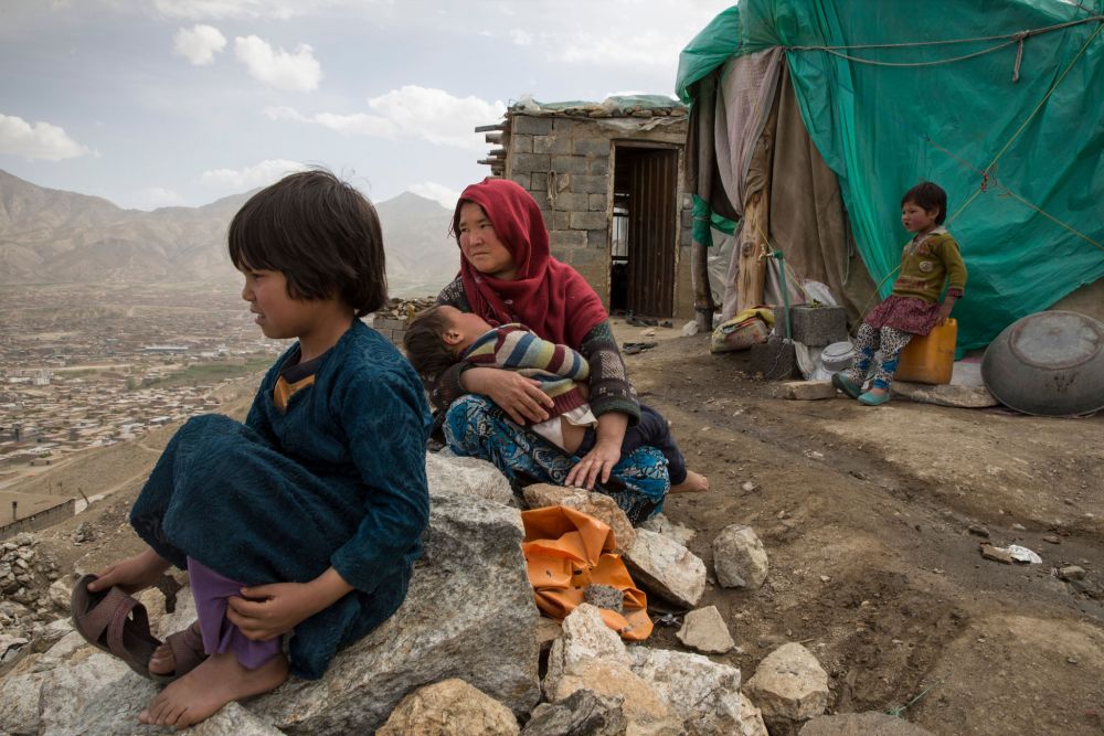 Asefa, whose husband was killed in an ethnic conflict, now lives with her six children in a tent, where they weave carpets to make money. She lost her husband three years ago during a battle between the Hazara and the nomadic Kuchi tribes. Image by Paula Bronstein. Afghanistan, 2015. Media file: 08_warwidows2015edit005.jpg