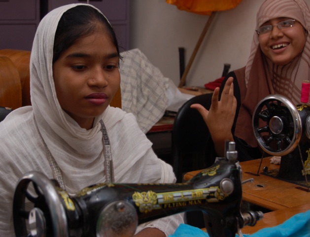 As Shompa shares her enthusiasm about the tailoring class, thirteen-year old Rozina concentrates on stitching her own dress. As she is deaf, it is hard to communicate with her. 1