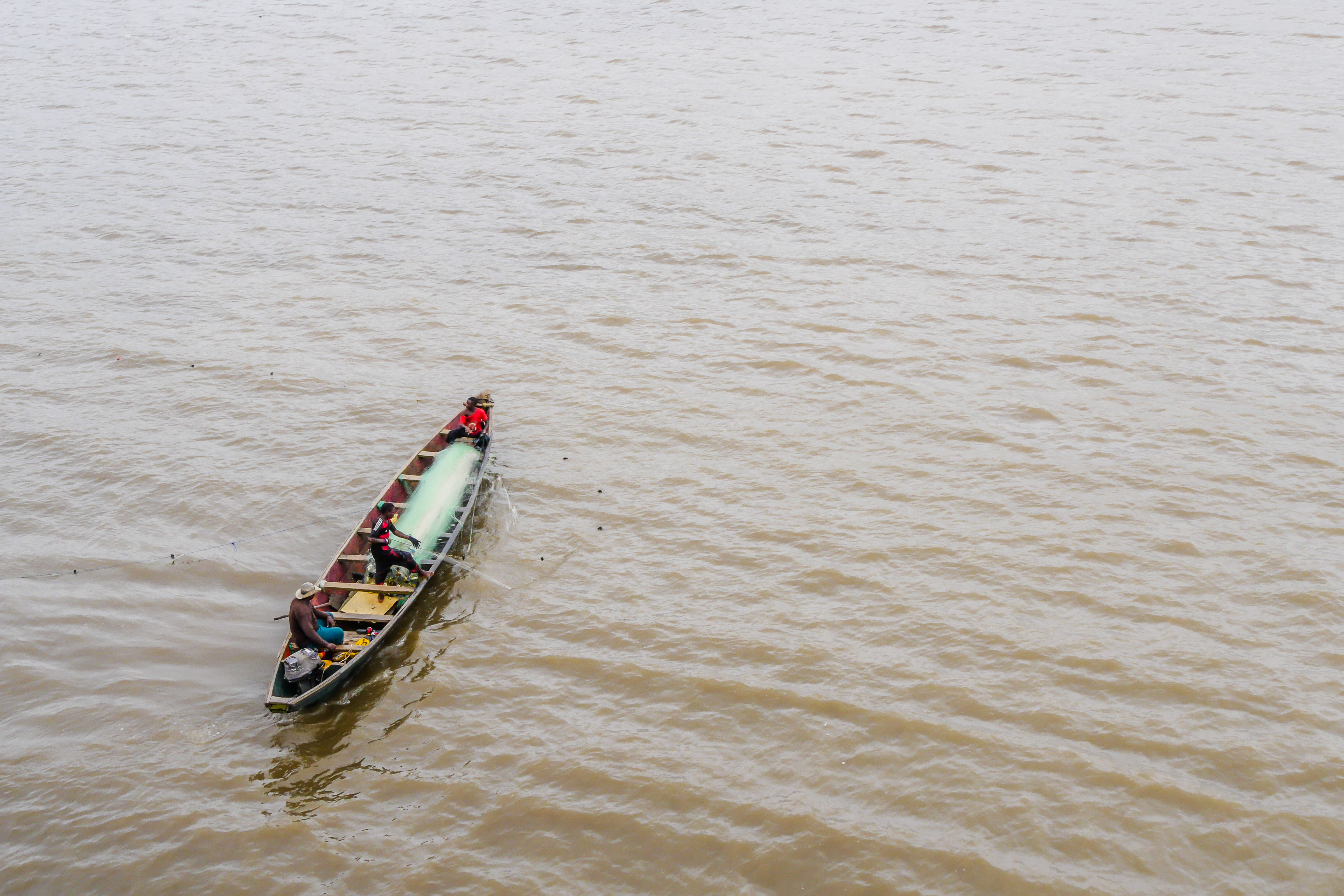 A man and his son fishing with a pirogue in the Wouri river, near the port of Douala. Image by Sidoine Mbogni/Shutterstock. Cameroon, 2019. A man and his son fishing with a pirogue in the Wouri river, near the port of Douala. Image by Sidoine Mbogni/Shutterstock. Cameroon, 2019.