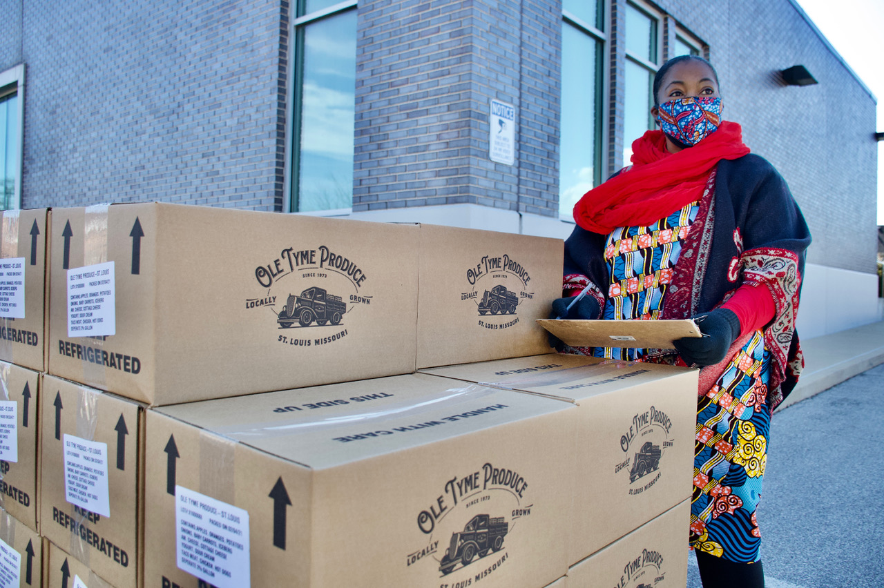 Kim_Daniel_with_produce_boxes_-Wiley_Price.jpeg Kim Daniel keeps track of food being distributed to residents during a food drive at the Flance Early Learning Center. Image by Wiley Price/St. Louis American. United States.