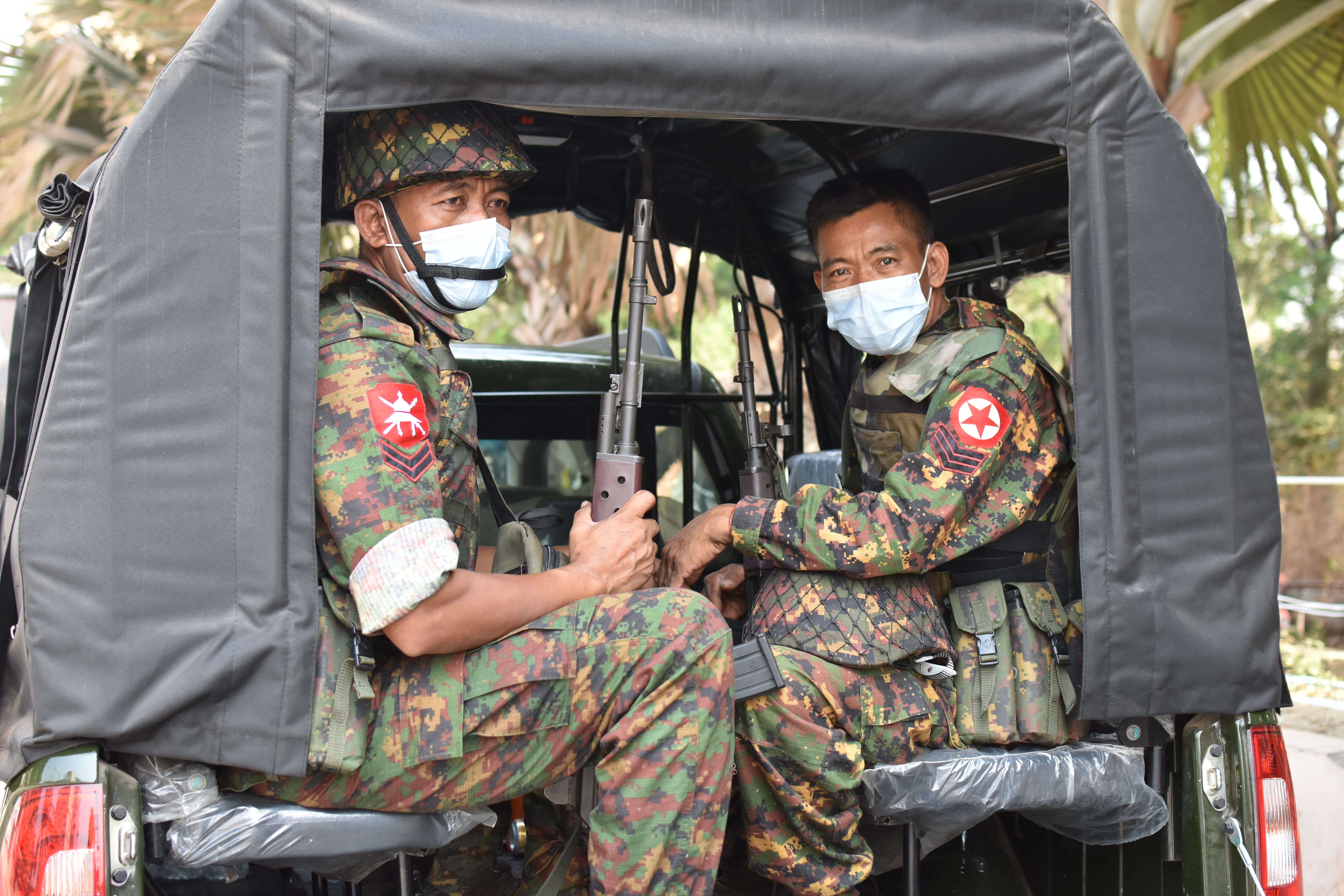 Military-soldiers-from-the-convoy-accompanying-the-press-tour.-March-31-2021_Allegra-Mendelson.jpeg Soldiers in medical face masks sit in a truck.