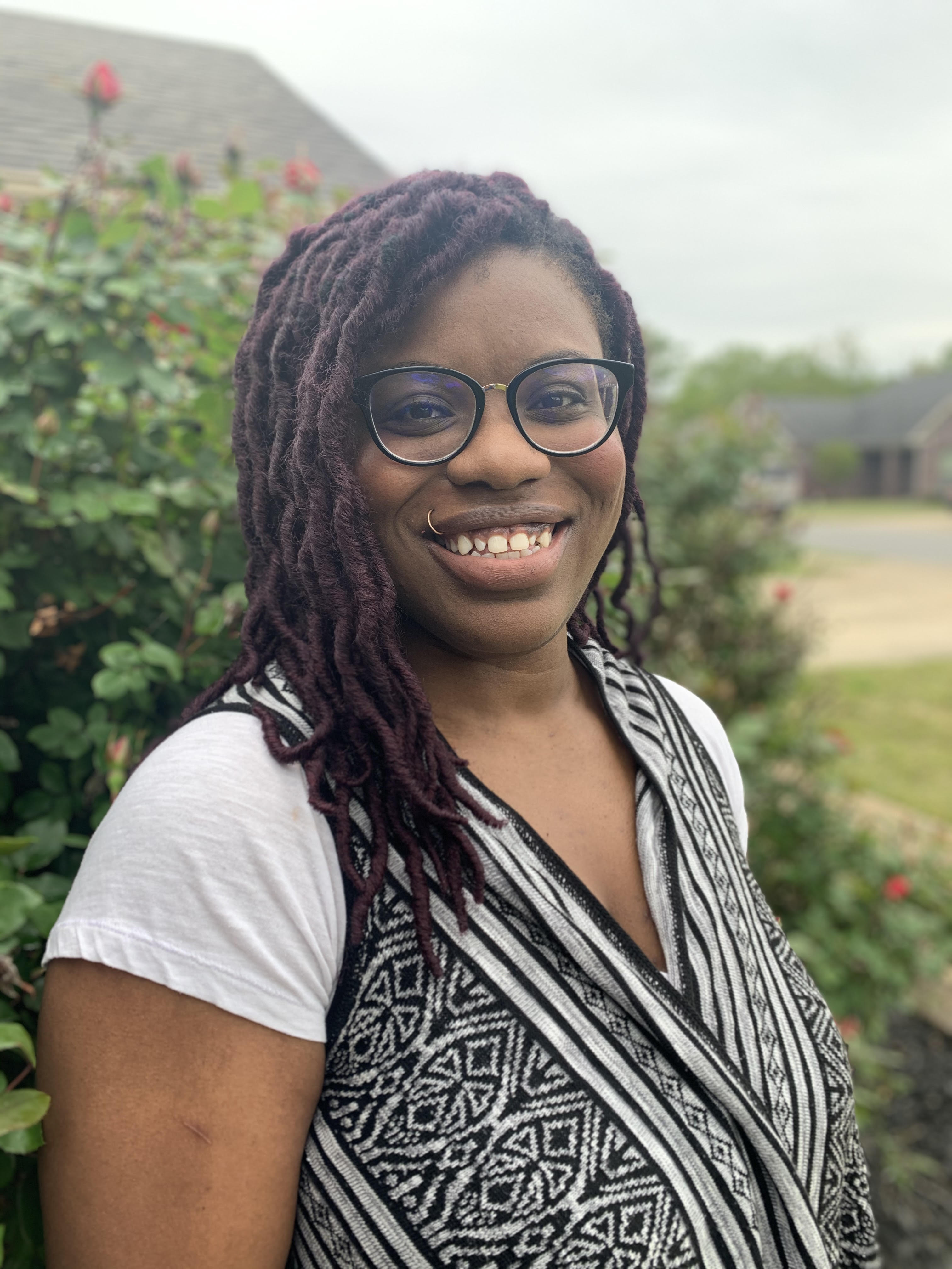 Donnalie Wilson stands in front of a rush rural landscape.