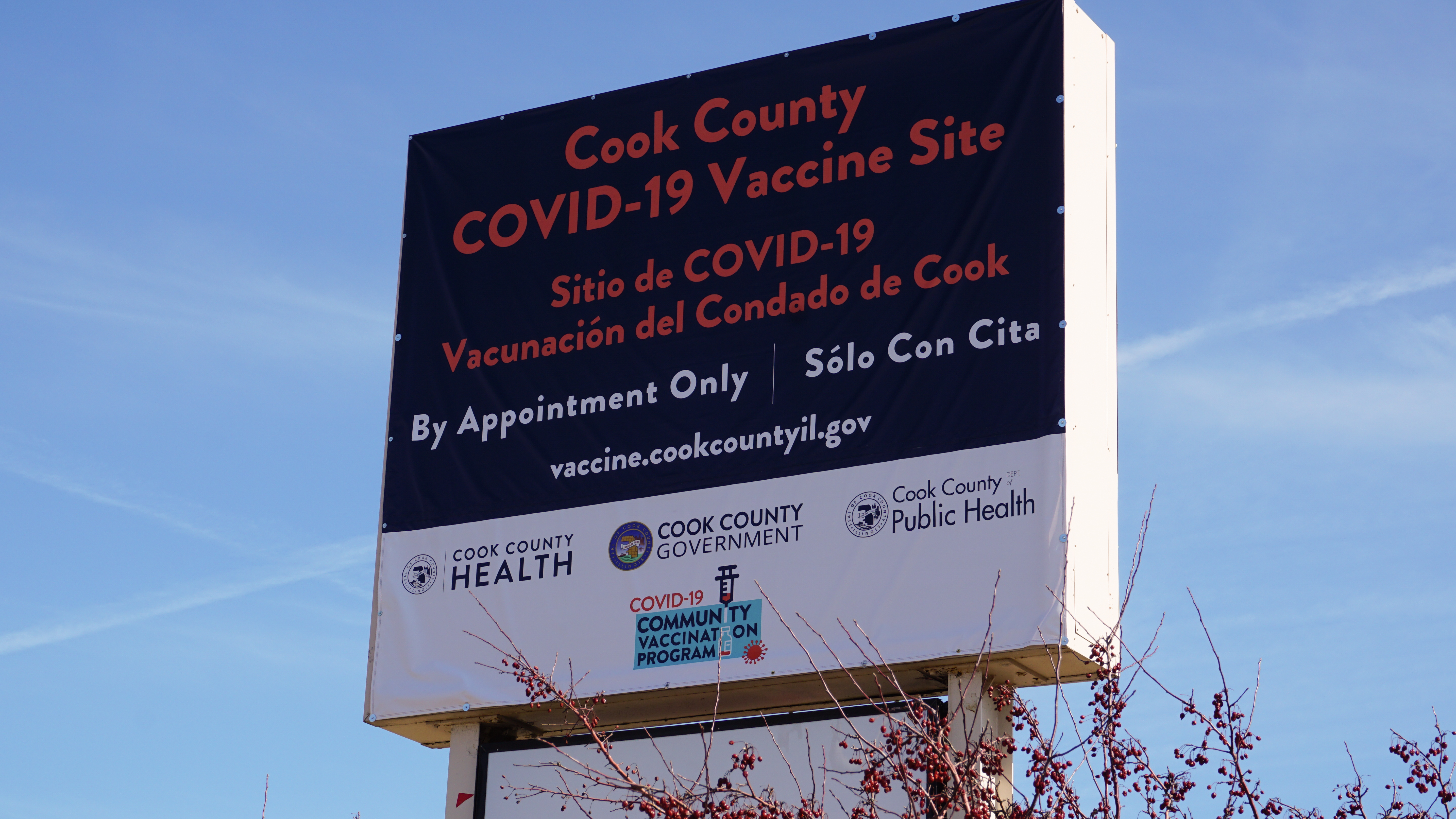 shutterstock_1937489404.jpeg A sign for a Cook County COVID-19 mass vaccination site in suburban Chicago. The sign is bilingual in English and Spanish.