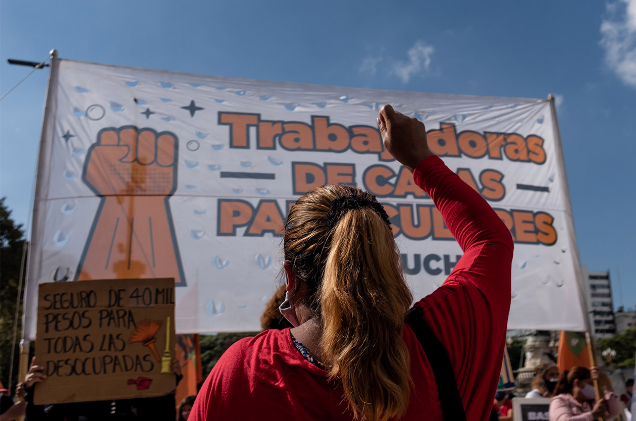 Someone, with their back to the camera, raises their fist during a protest.