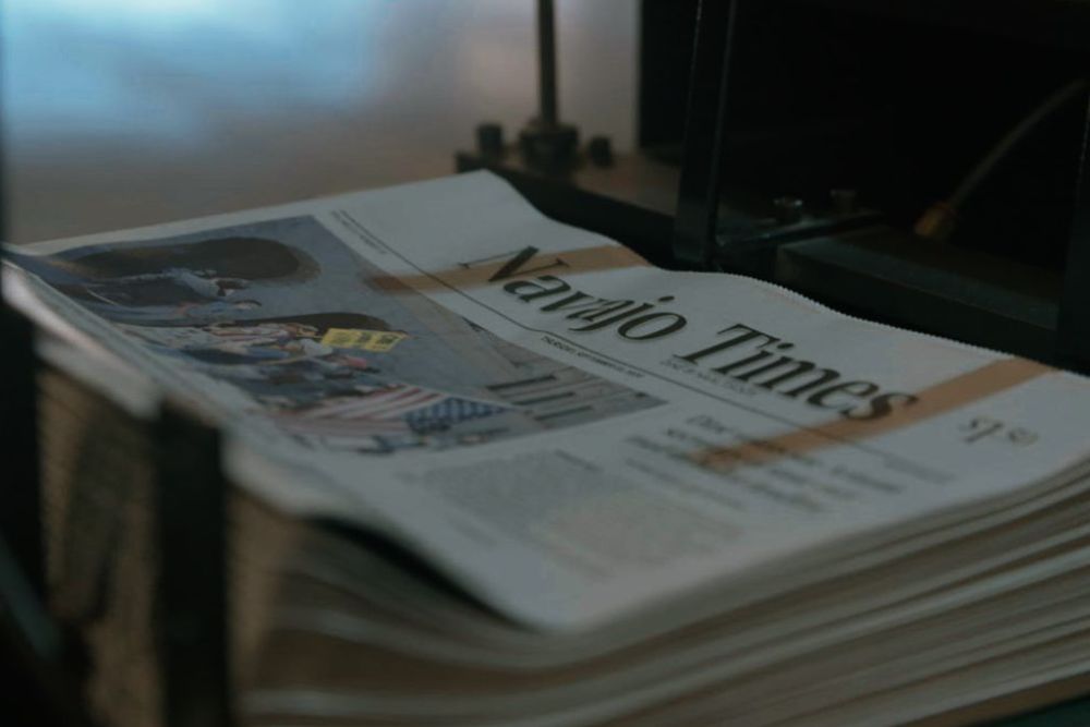Copies of The Navajo Times newspaper are stacked together