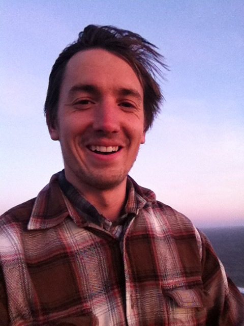 Photo of Nate Hegyi in plaid shirt at sunset