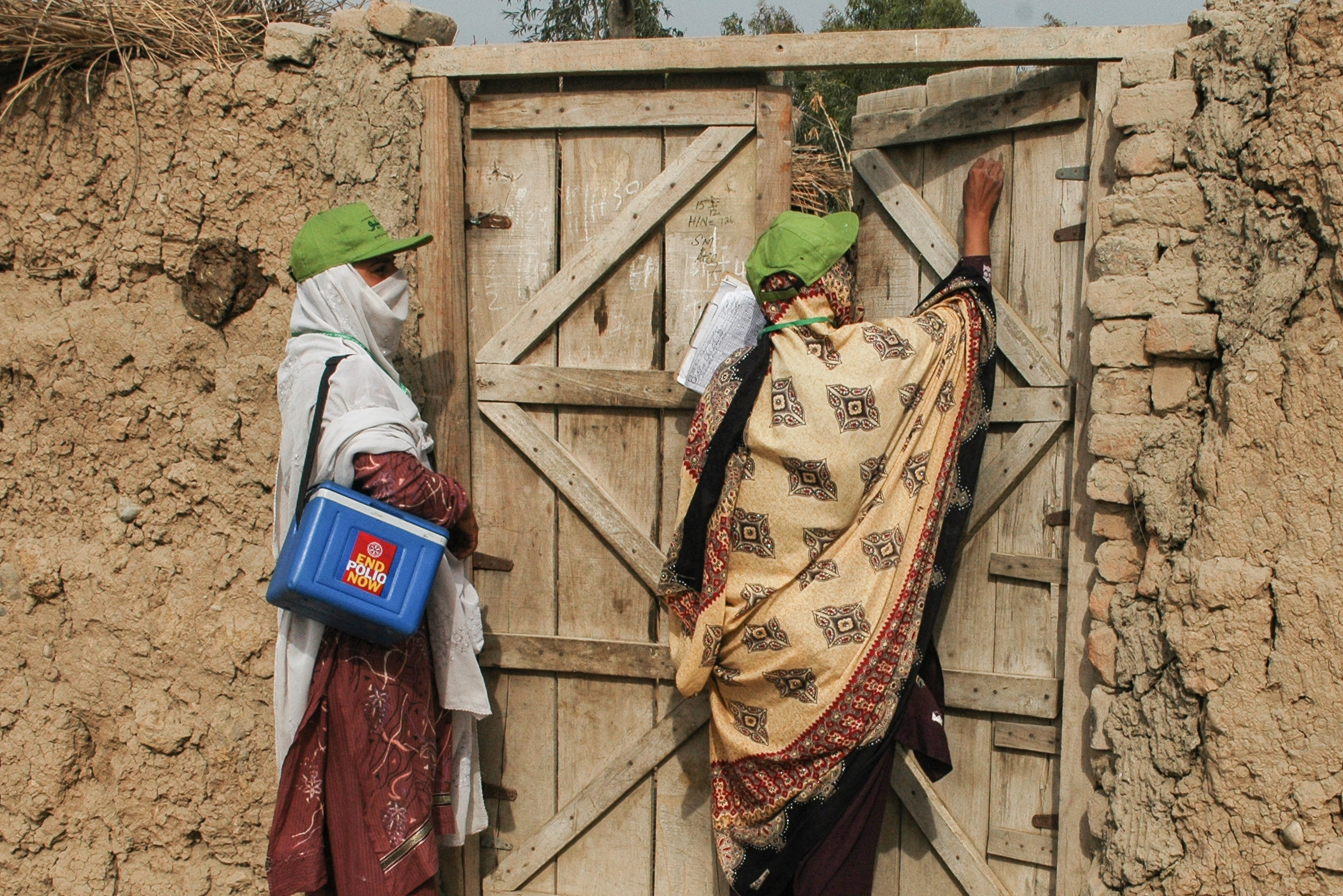 shutterstock_1199293960.jpg A female polio worker marks a house as visited after vaccinating children at a Christian colony in Lahore, Pakistan.