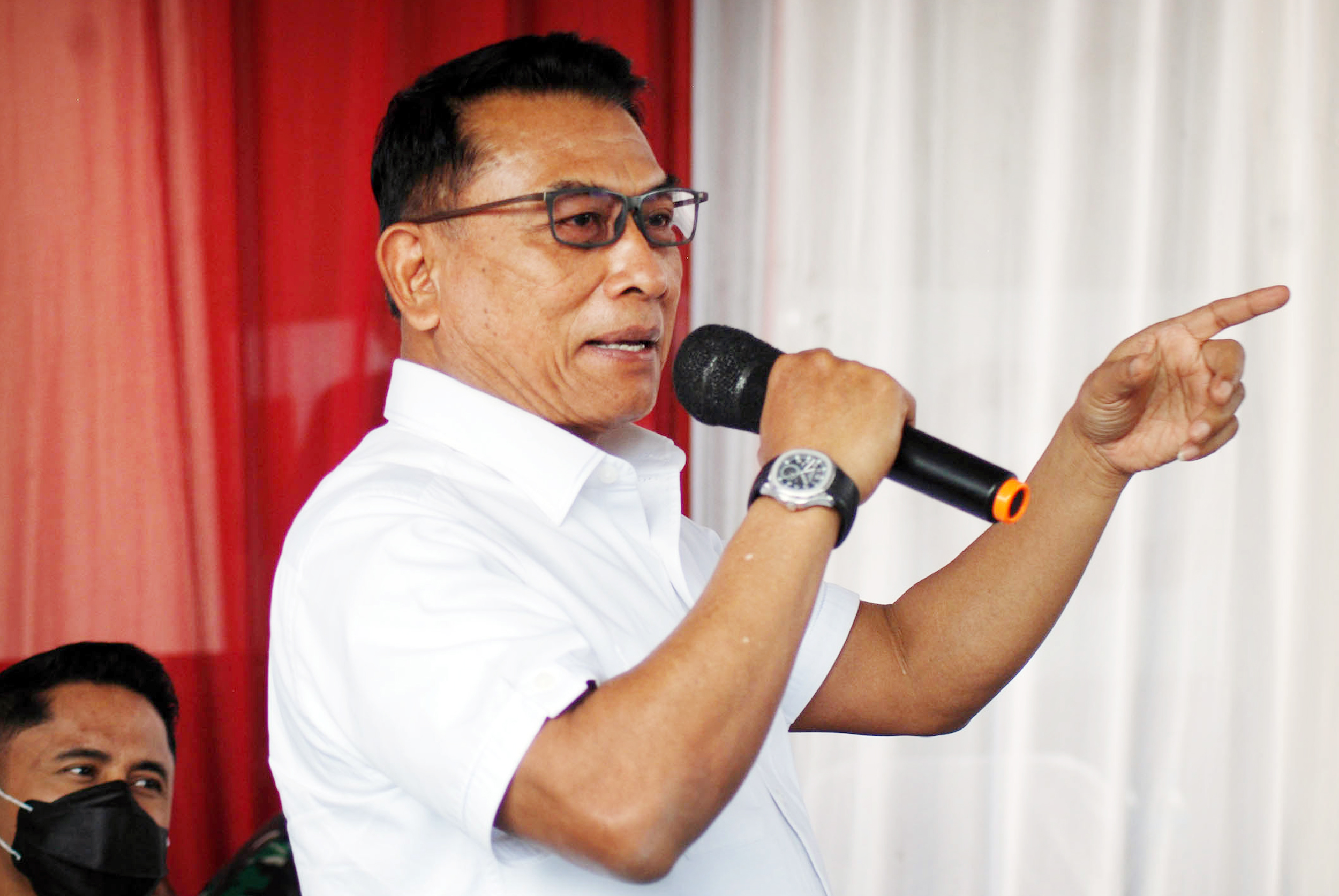 Presidential Staff Office Chief Moeldoko holding a microphone at a press conference