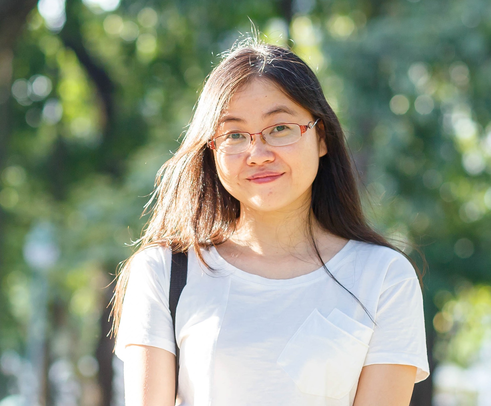 A person wears glasses and a white shirt.