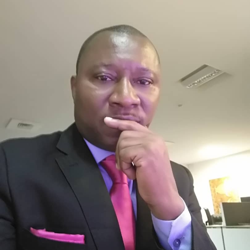 A man wearing a red tie and a black jacket.