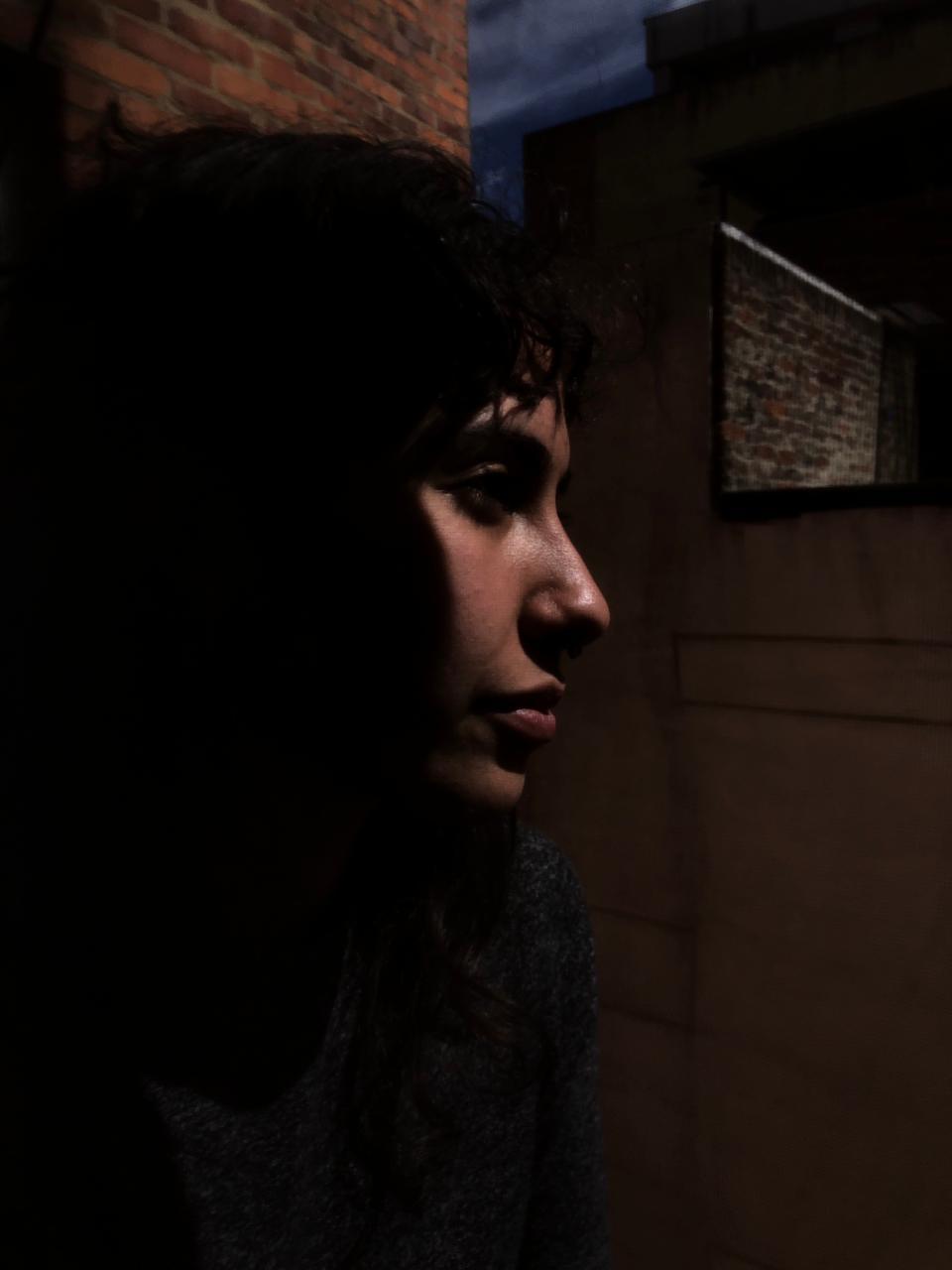 A woman poses with her profile facing the right