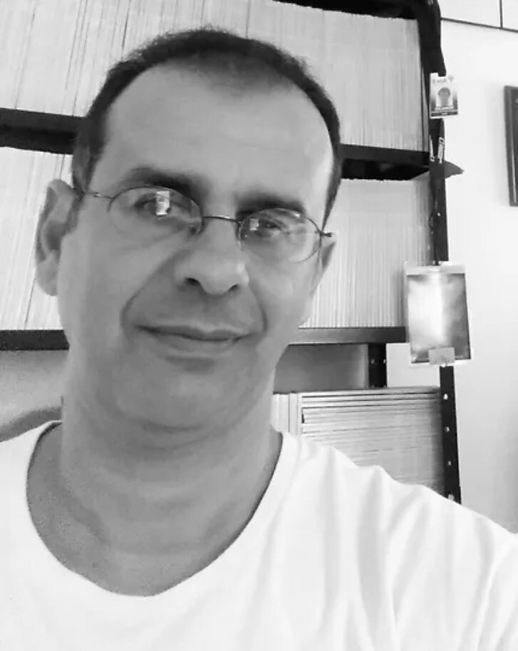 A person wears a shirt and glasses.