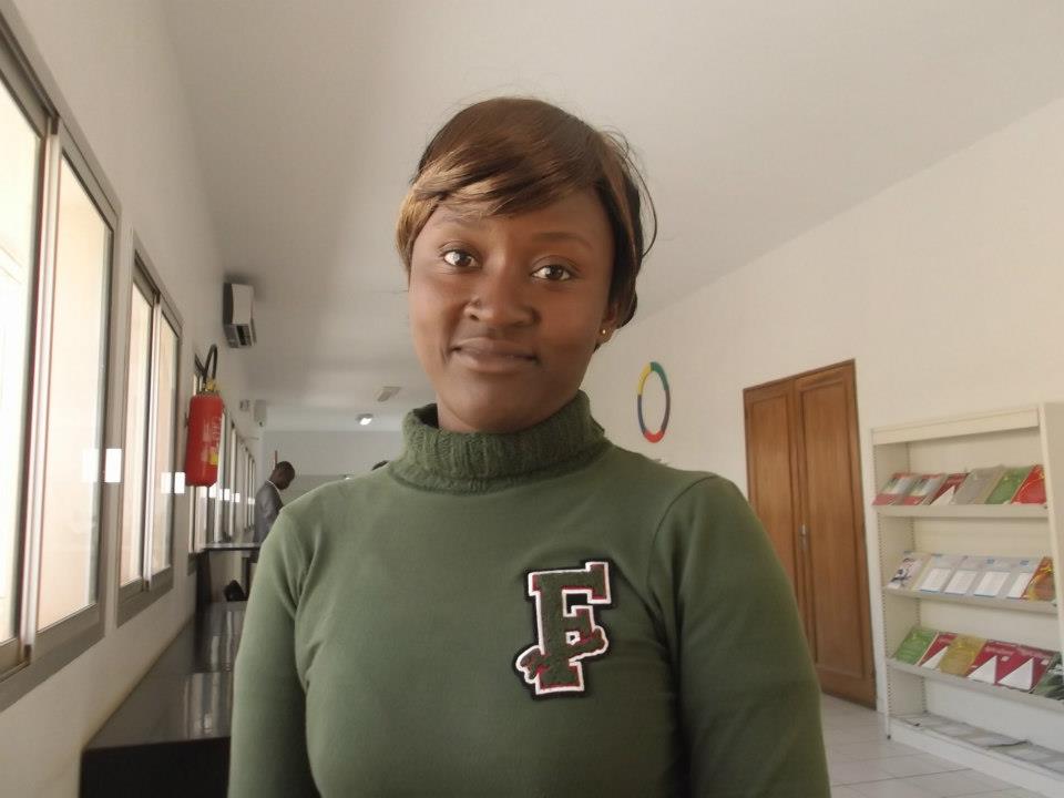 A woman with brown hair is wearing a dark green sweatshirt with the letter F.