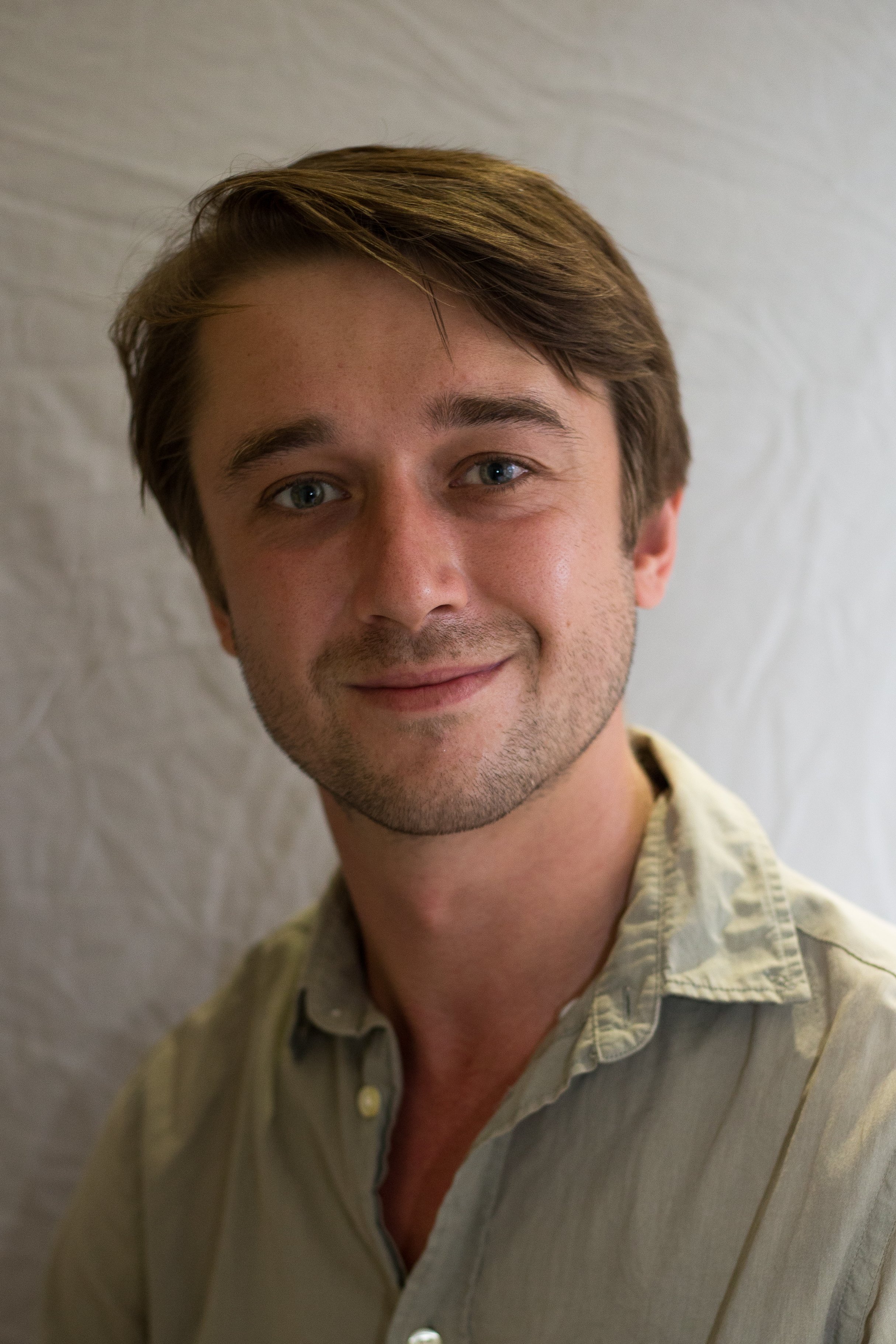 A person wears a green work shirt with buttons.