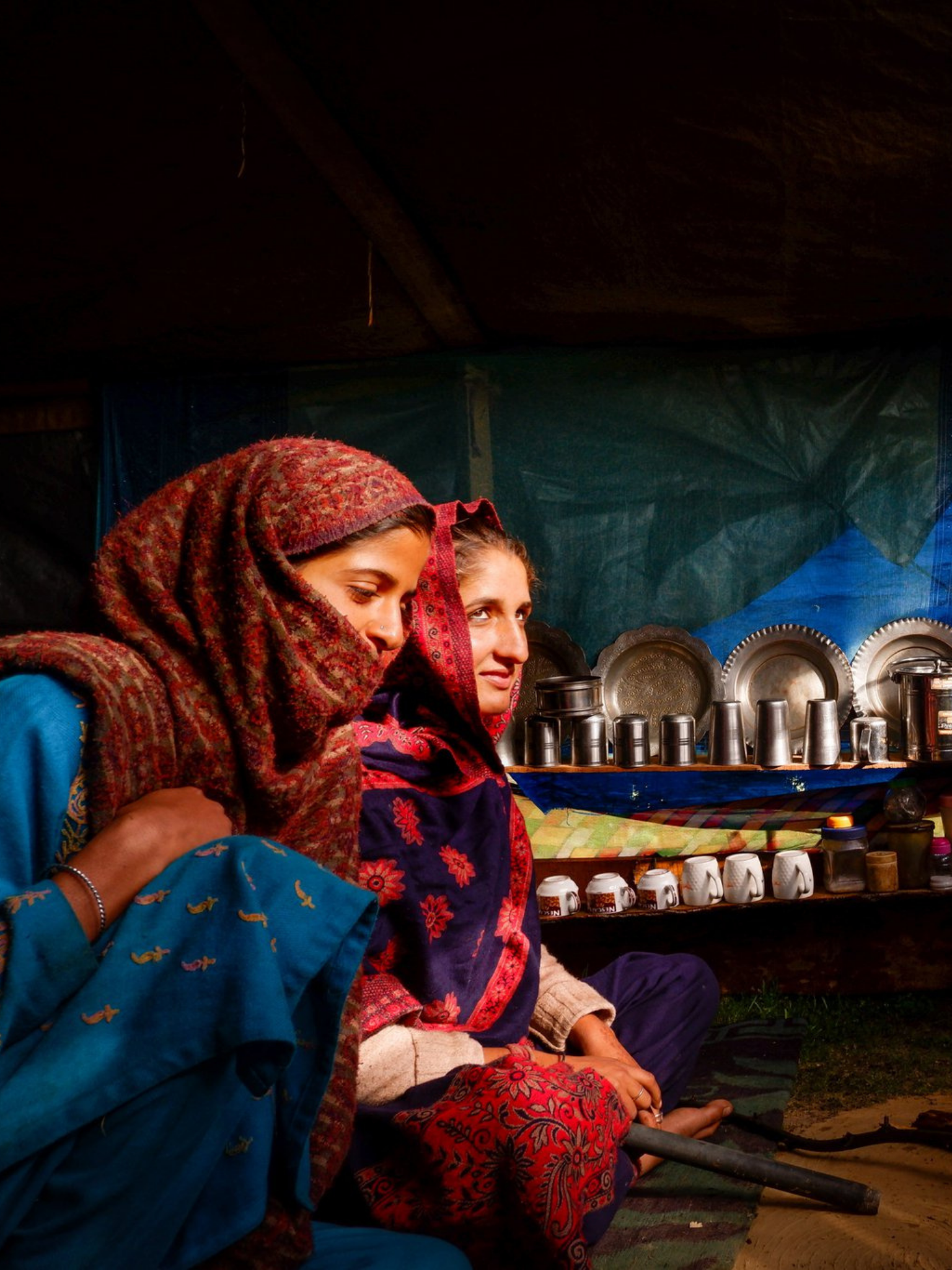 two young women sit in their tent