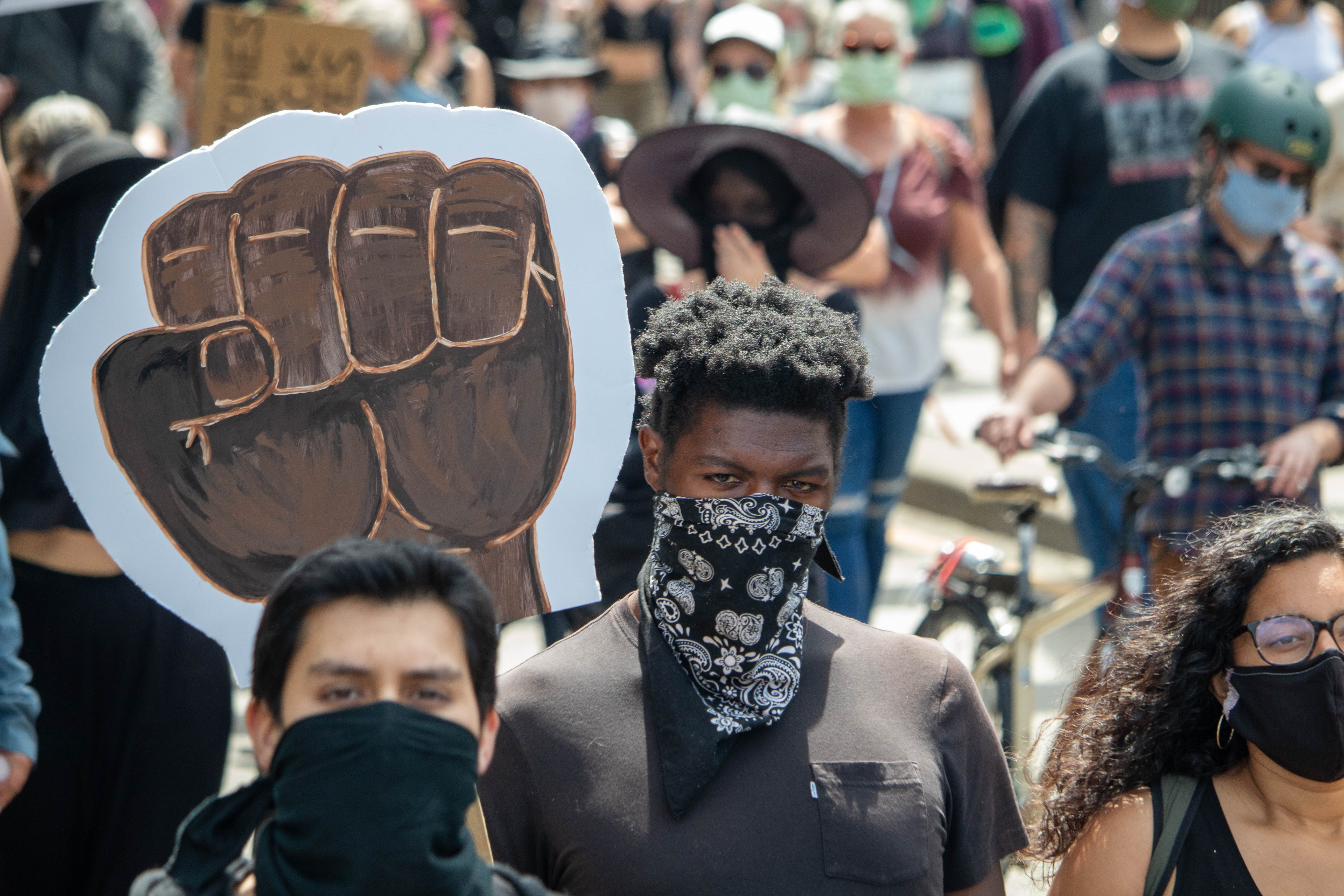 Individuals march in direction of photographer.