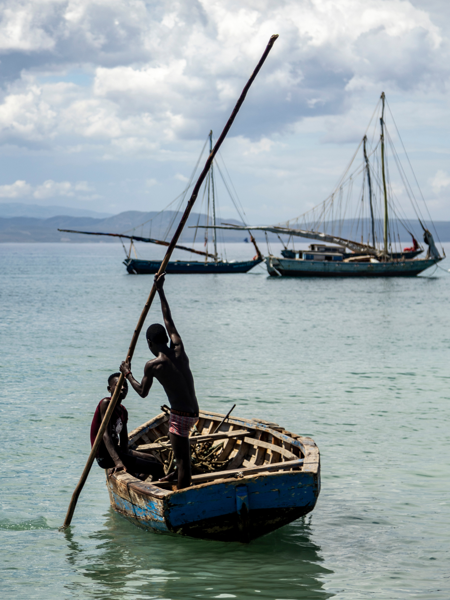NEW S. Copy of Vertical thumbnail template 34 (1536 × 2048px) template (4).png Young boys row a small boat in bright blue Caribbean waters