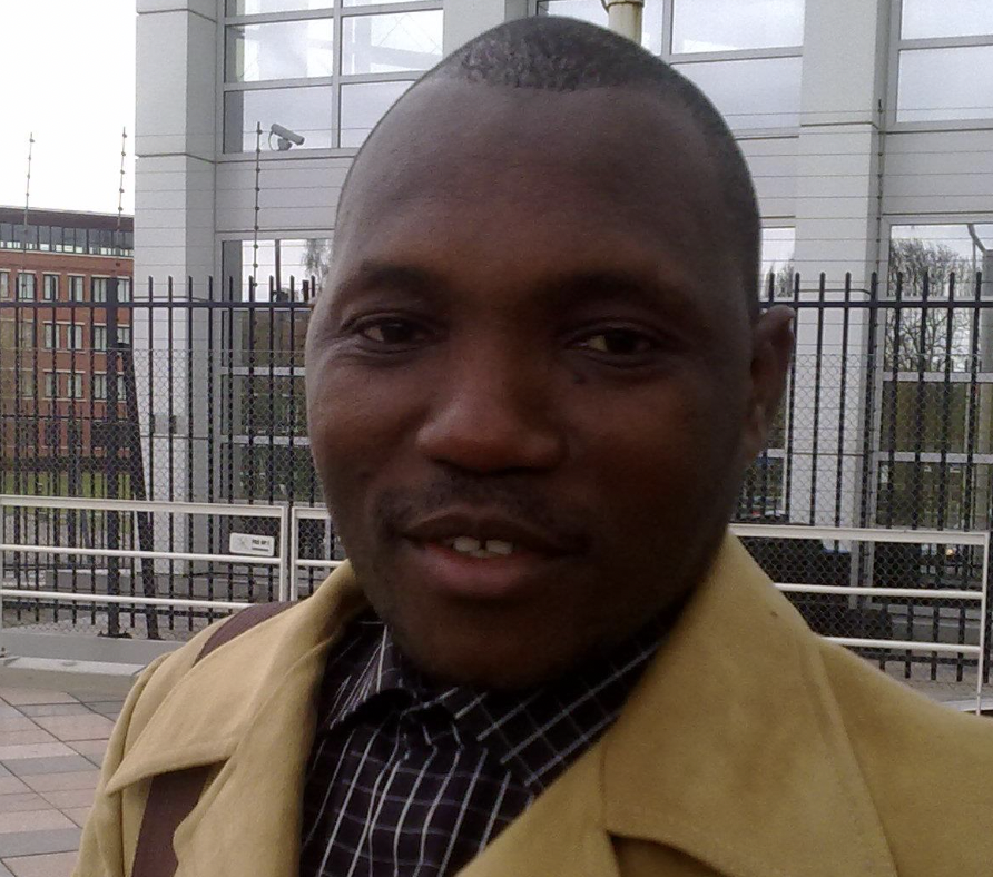 A man wears a brown jacket with a brown shirt.