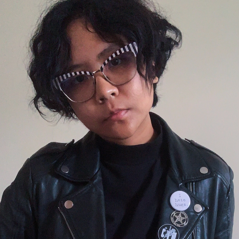 a woman with large glasses stares into the camera