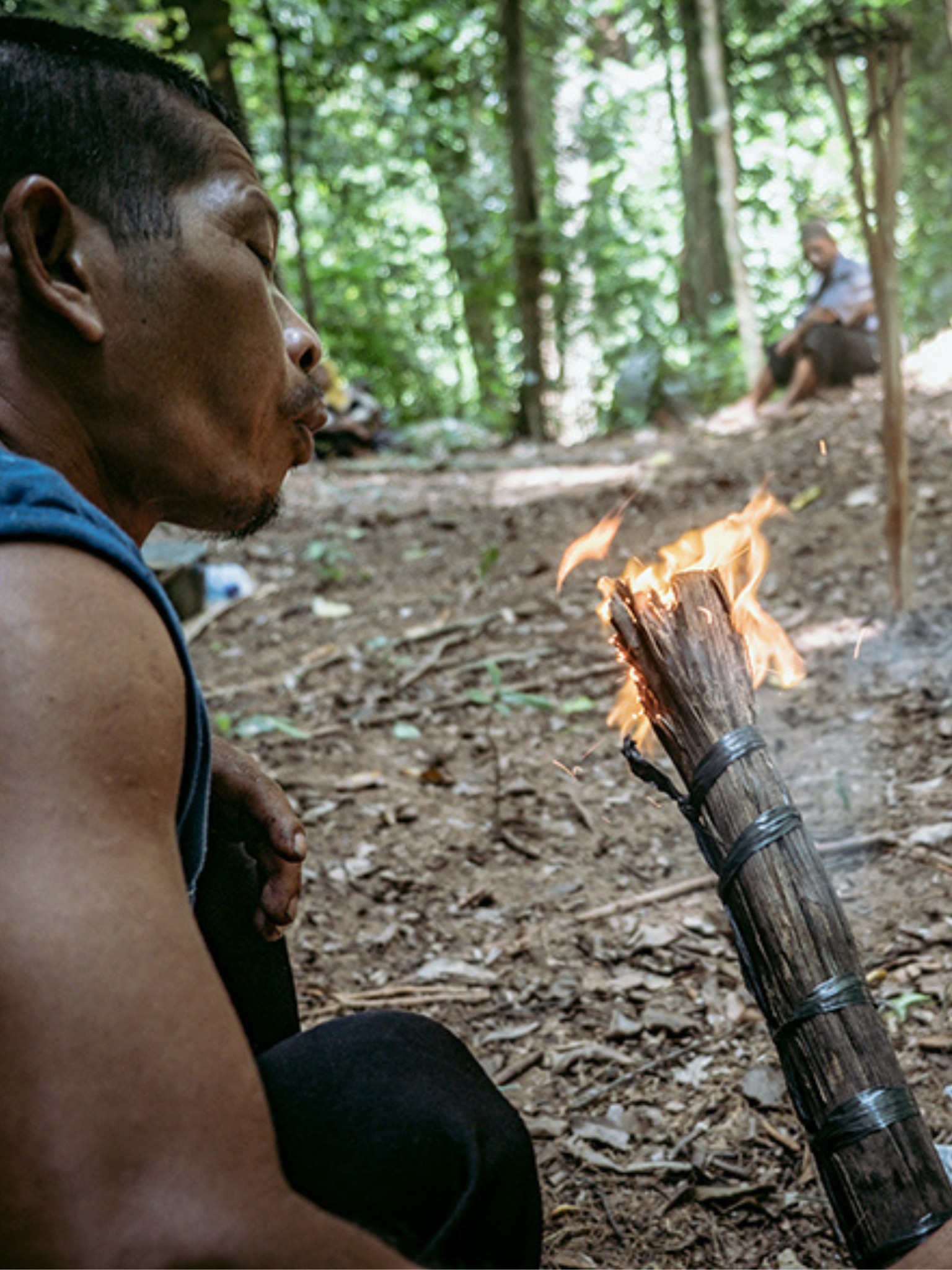 a man blow a torch in a forest