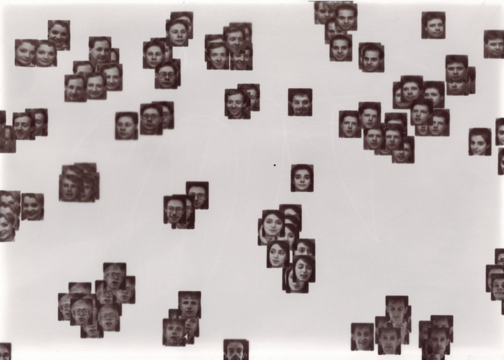 Philipp Schmitt & AT&T Laboratories Cambridge / Better Images of AI / Data flock (faces) / CC-BY 4.0 A laptopogram based on a neutral background and populated by scattered squared portraits, all monochromatic, grouped according to similarity. The groupings vary in size, ranging from single faces to overlapping collections of up to twelve. The facial expressions of all the individuals featured are neutral, represented through a mixture of ages and genders.