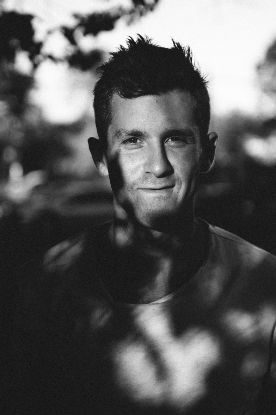 Black and white photo of a man under a tree