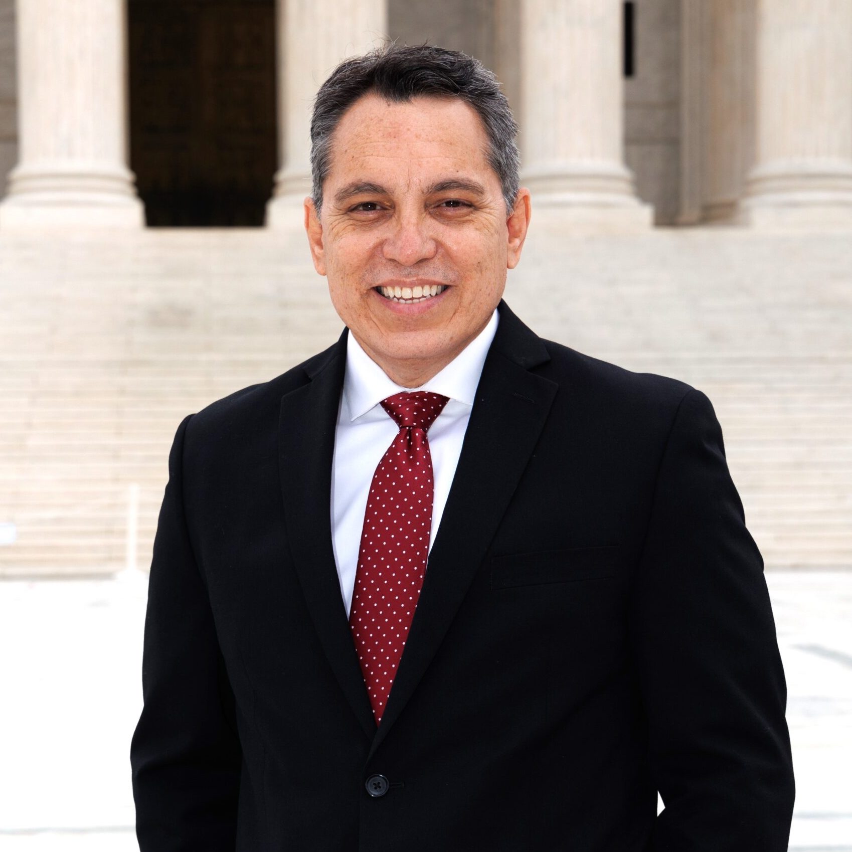 Man in black suit and red tie