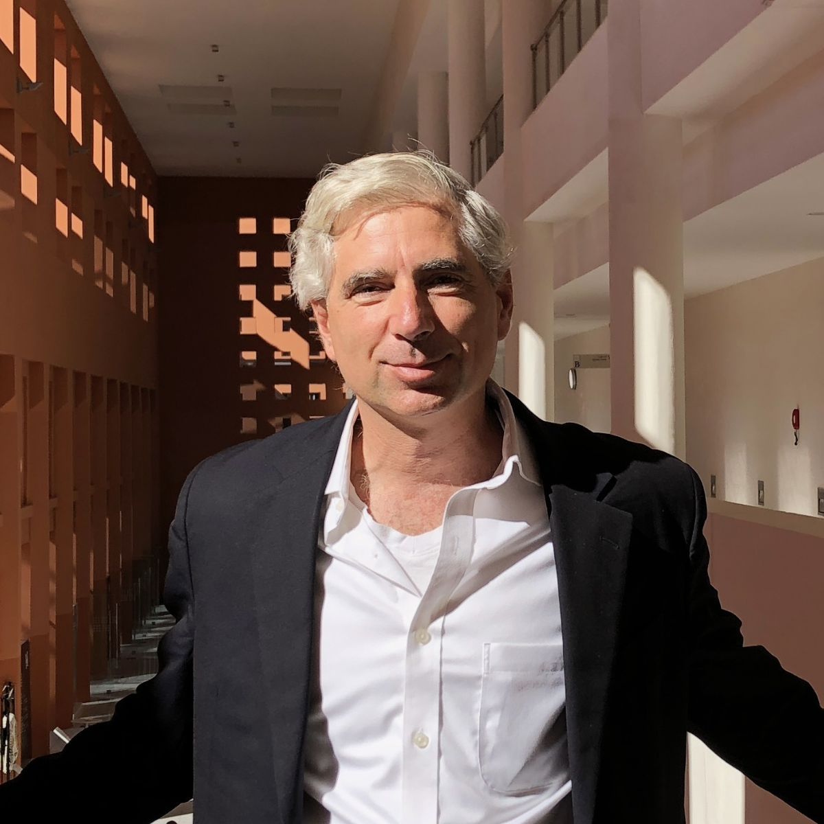 Headshot of man in black suit jacket and white button down