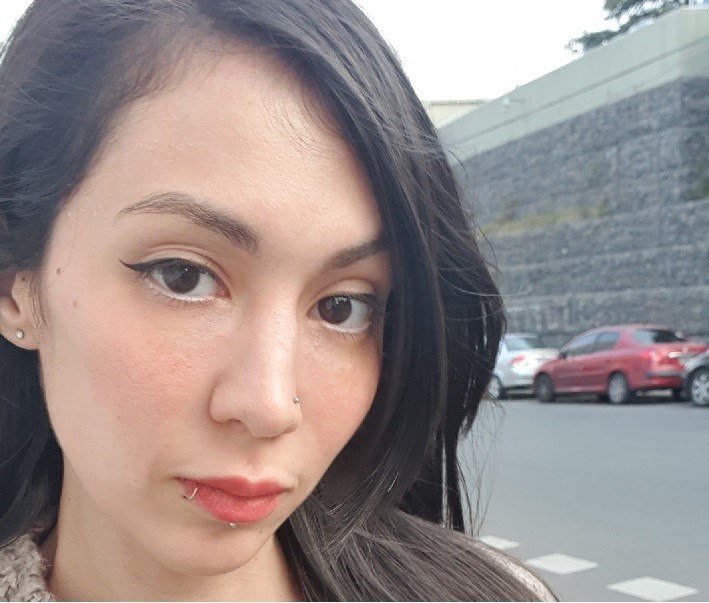 Image of a woman with long dark hair on a city street