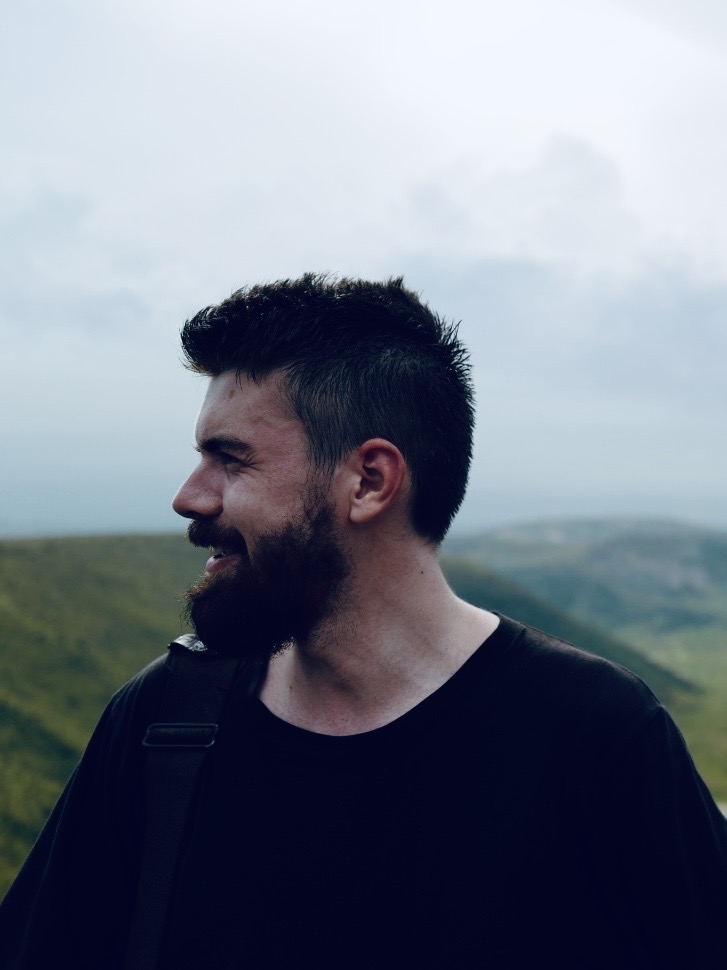 Side profile of Hugh against a mountainous background