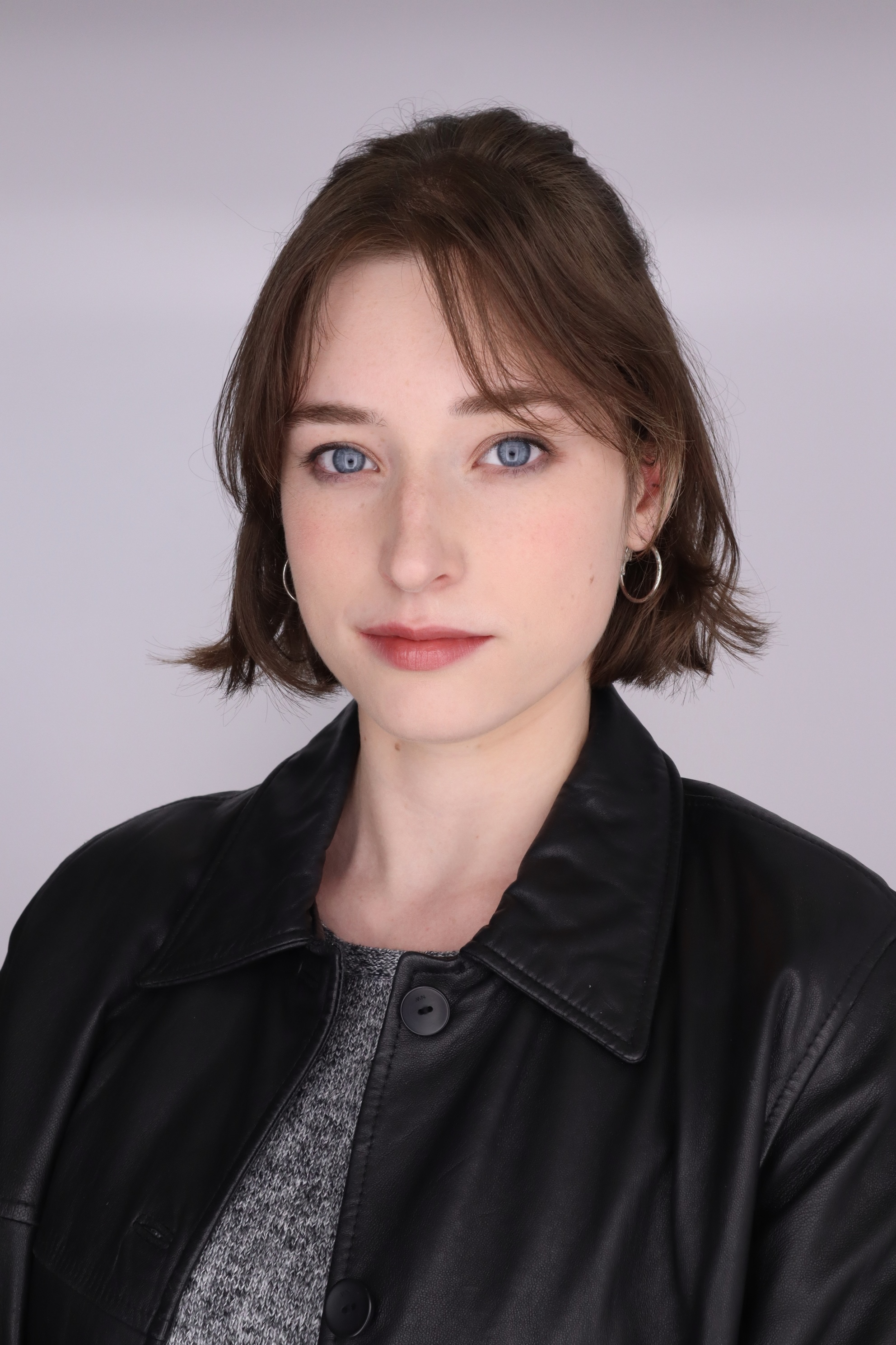 Headshot of Alyson wearing a leather jacket and grey shirt