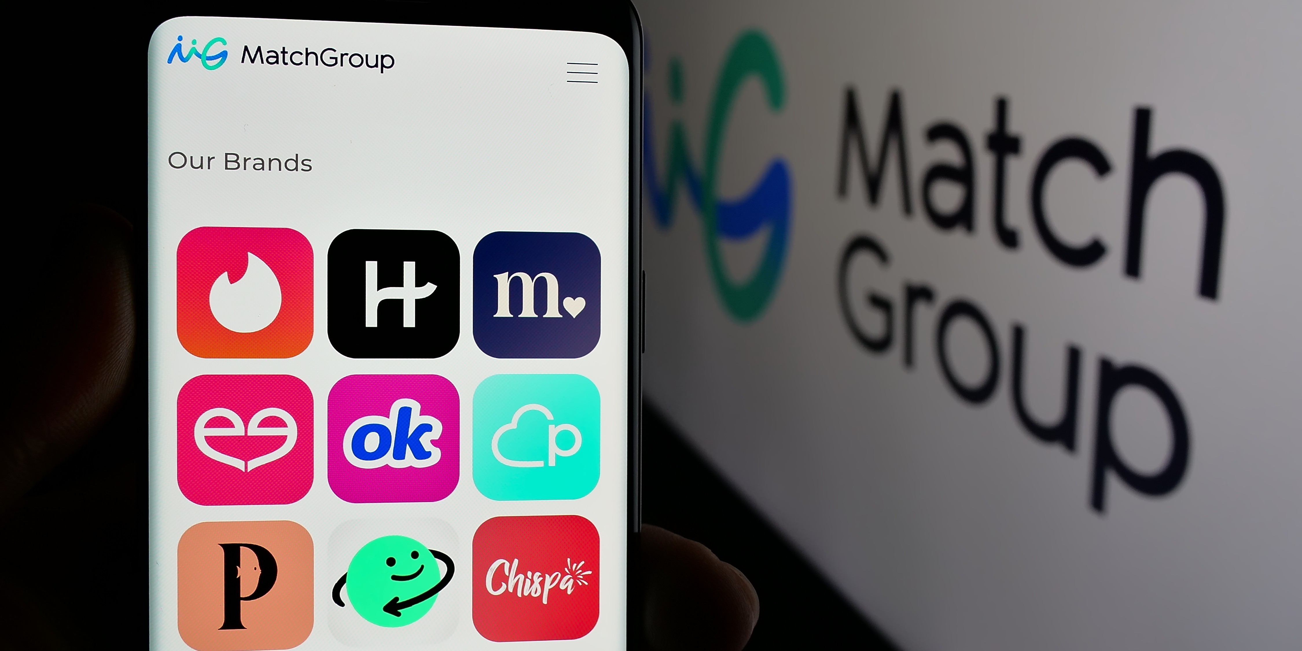 Image of phone with dating apps like Tinder and Hinge next to screen with brand logo for Match Group company