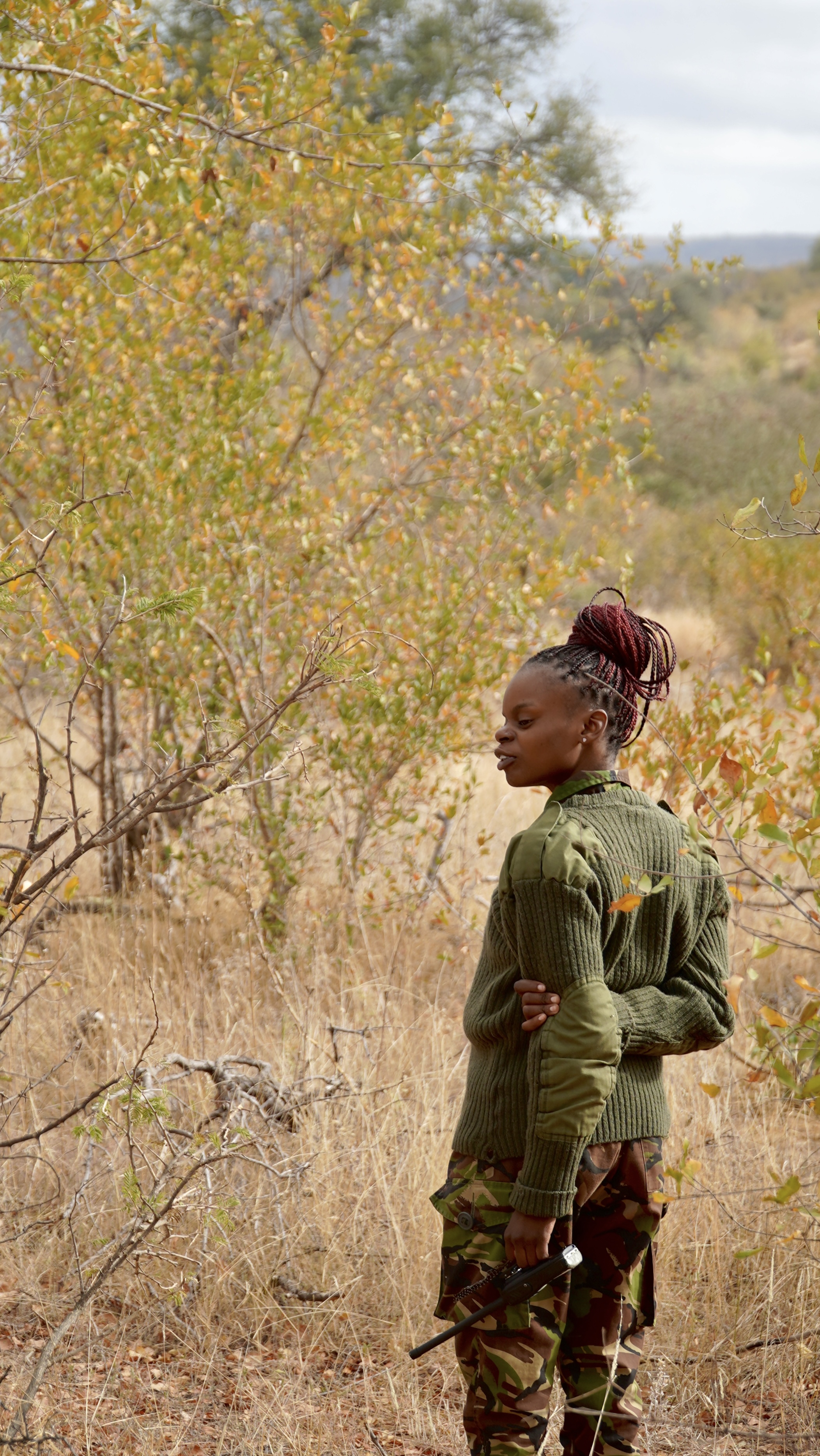 Black Mamba ranger Naledi Malungane scans the bush in the Balule Nature Reserve of Kruger National Park on the lookout for snares set by poachers. Photo by Olivia Lockett. South Africa, 2025.