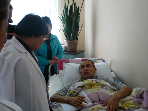 Roza Otunbayeva, Kyrgyzstan’s interim leader, talks to one of the victims of the revolution, recovering in his hospital bed. Almazbek Akchekeyev, a police officer, lost both legs in a grenade explosion on April 7. 1