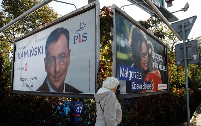 A woman walks in front of election posters in Warsaw. Image by Kacper Pempel. Poland, 2019. A woman walks in front of election posters in Warsaw. Image by Kacper Pempel. Poland, 2019.