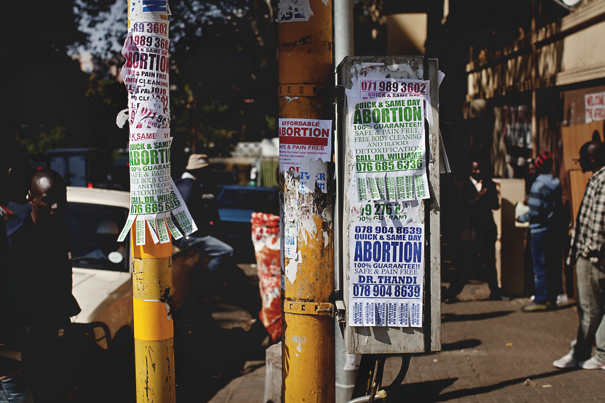 Posters advertising illegal abortions can be seen all over downtown areas, like the ones above in Hillbrow neighborhood of Johannesburg. Image by Jake Naughton. South Africa, 2012. Media file: Abortion-crisis.jpg