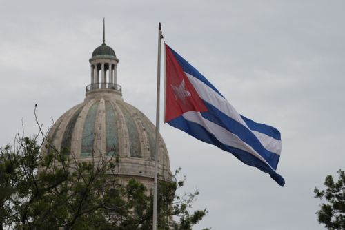 Havana's Capitolio with the Cuban flag waving in the background. 1