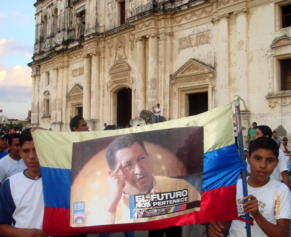 Young Nicaraguan Sandinistas hold a sign of support for Venezuelan President Hugo Chavez outside the cathedral in León, Nicaragua. Image by Tim Rogers. Nicaragua, 2012. Media file: Chavez sign Leon.jpg