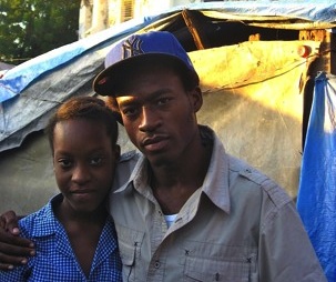 Cynthia Desert and her brother Ernso in the tent camp where they live in Port-at-Prince, Haiti. Behind them stands what remains of St. Anne's church after an earthquake struck the area two years ago. Image by Kem Knapp Sawyer. Haiti, 2012.