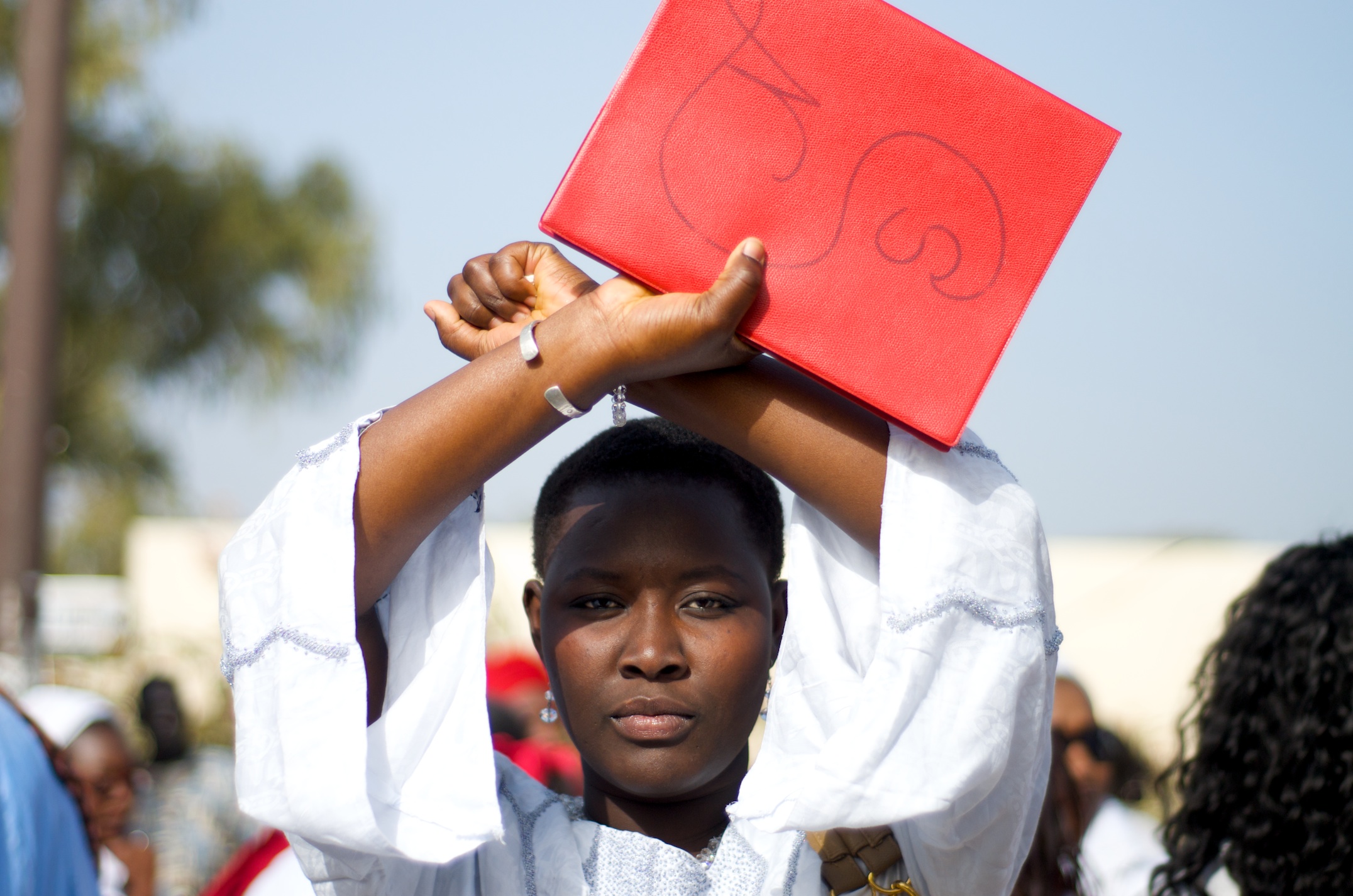 A woman in Dakar, Senegal makes the opposition symbol days before Presidential elections in the West African country. The ‘X’ symbolizes the bound hands of the Senegalese people. Image by Ricci Shryock. Senegal, 2012.